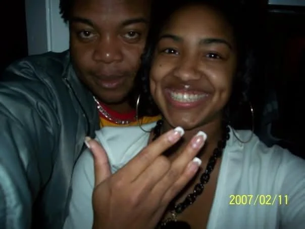 A man and a woman smiling and posing for a selfie, with the woman displaying her fingernails. The date 2007/02/11 is in the bottom right corner.