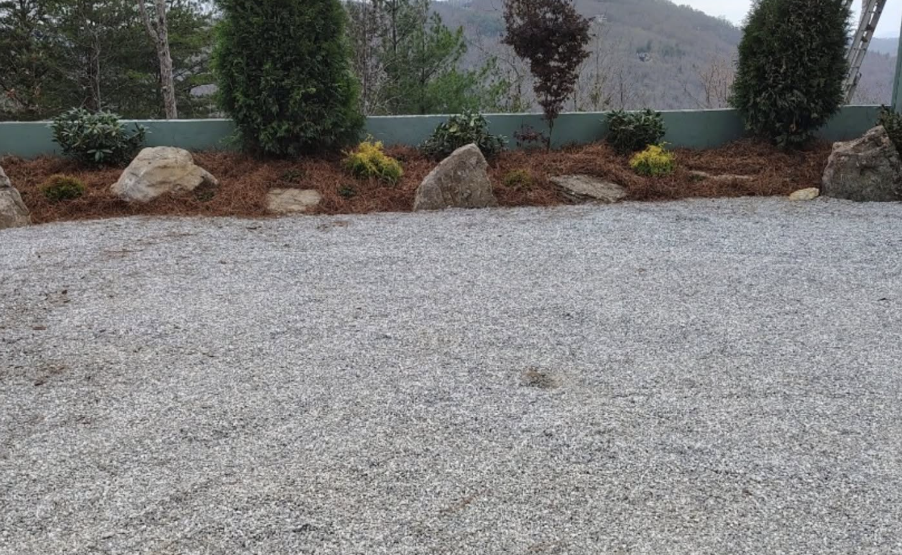 Completed gravel driveway installation with decorative landscape beds and fresh stone by Pro Turf LLC.