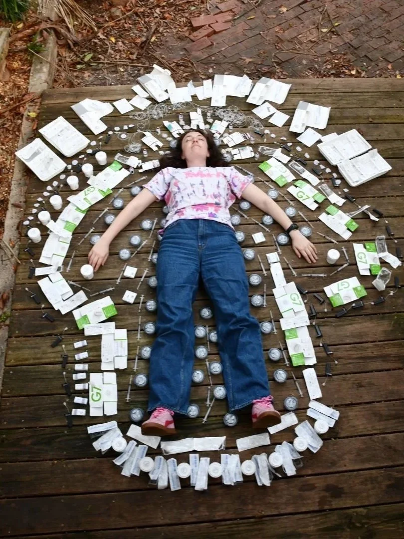A person lying on the floor surrounded by three months of diabetes-related waste