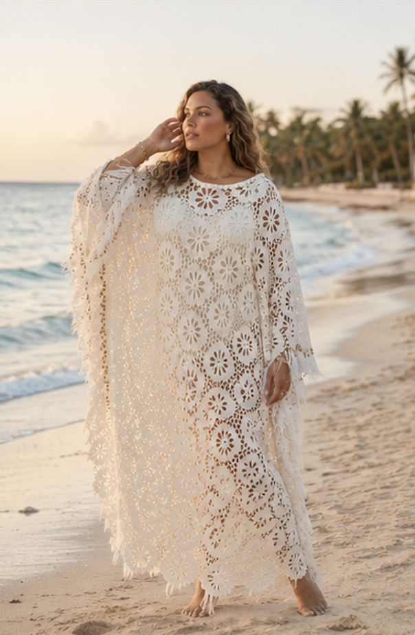 THE BOHEME CAFTAN: An airy eyelet caftan embellished with natural wooden beads, delicate ostrich feathers, and playful pom-pom trim. 