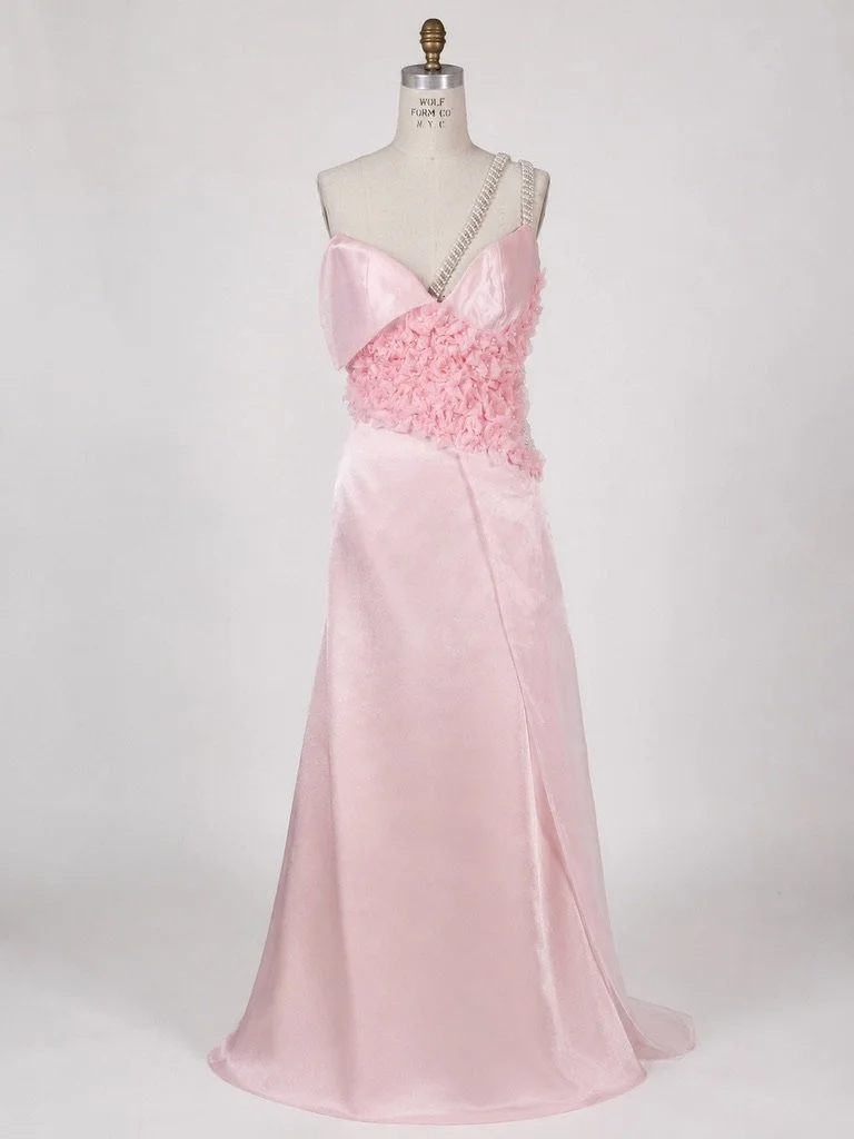 BLUSHING BRIDAL GOWN — A bridal gown crafted in Italian satin and organza, featuring an asymmetrical bodice with sculptural hand-beaded organza flowers, layered floral appliqué, and intricate couture embellishment throughout.