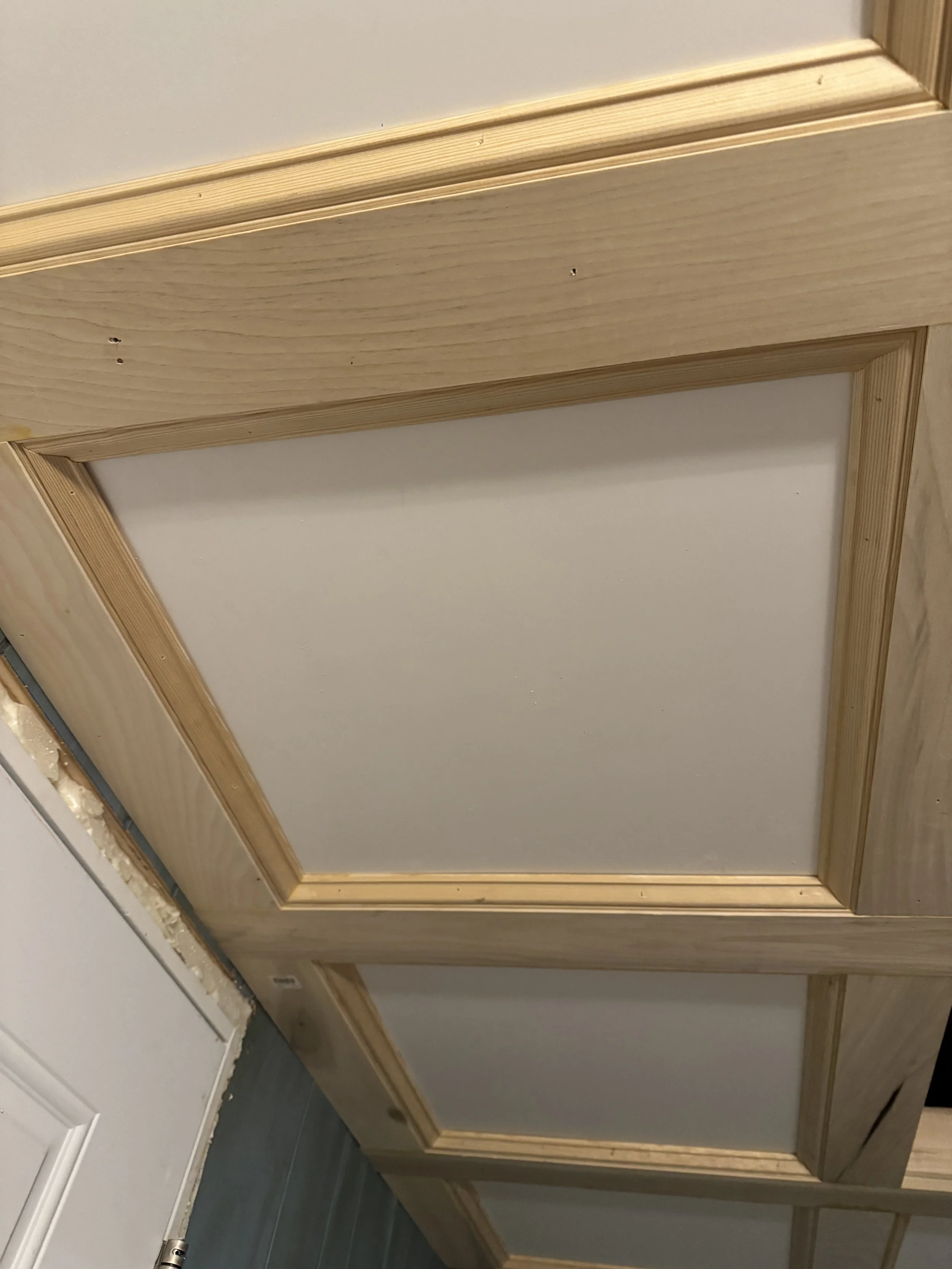 Close-up view of a built-in cabinet with wooden frame and white panels.