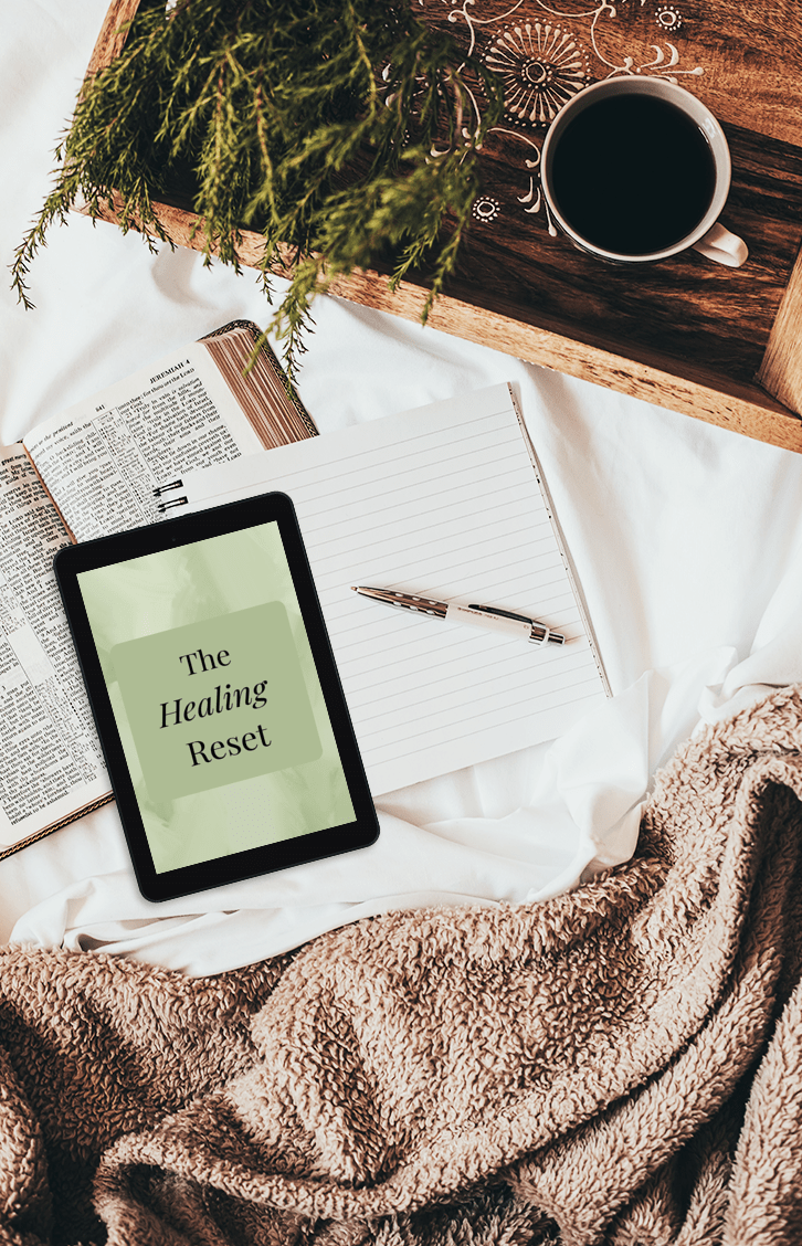 Tablet displaying The Root Cause RN Wellness Reset guide resting on a cozy blanket — a holistic wellness resource for women