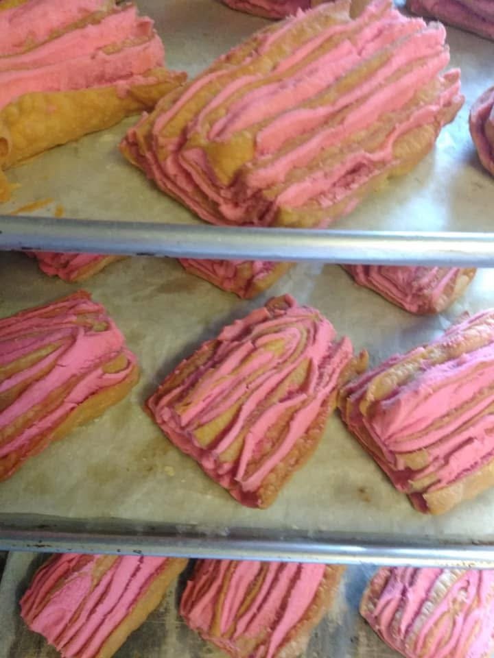 Pink and beige striped layered pastries on baking sheets.