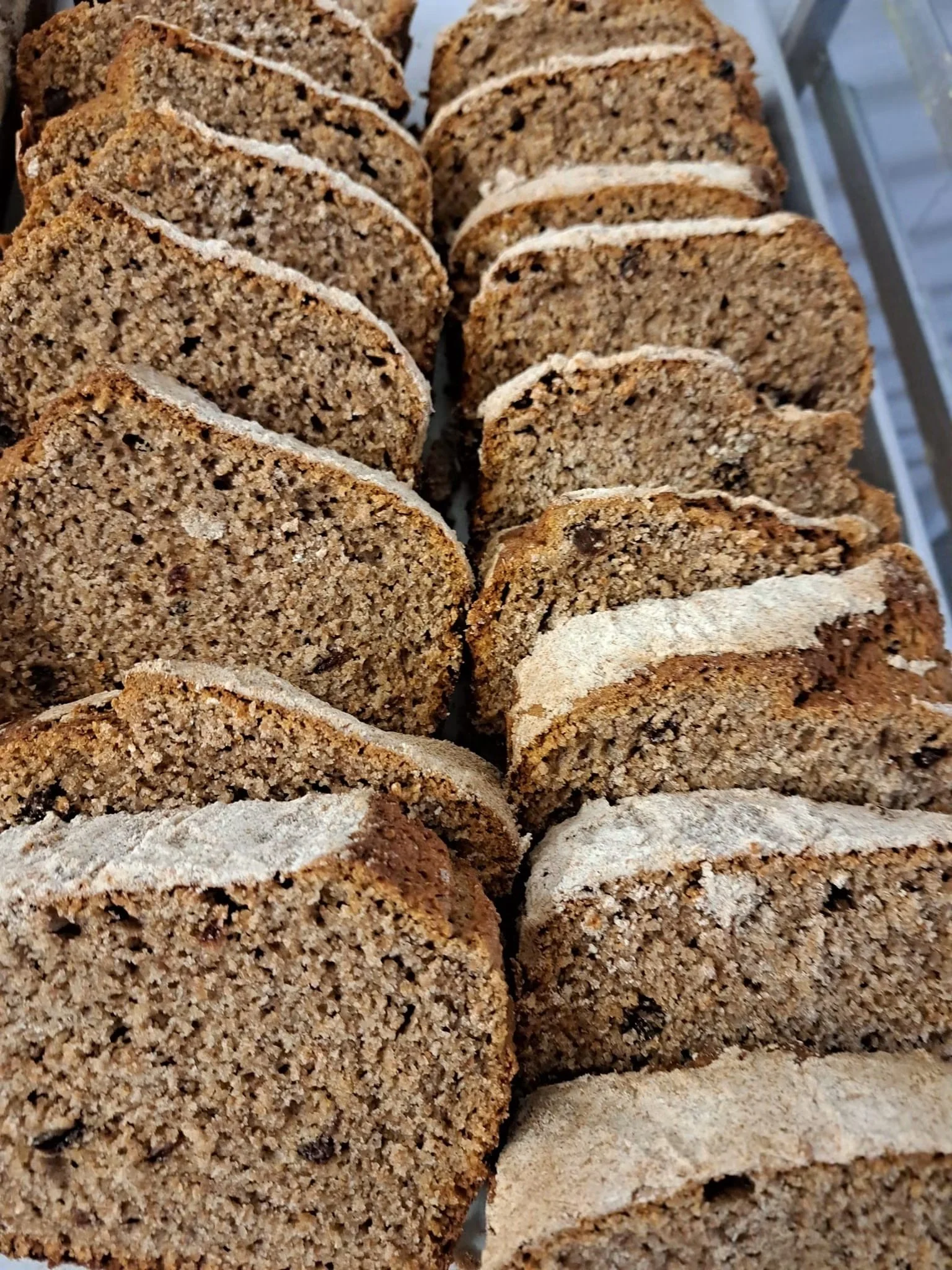 Close-up of sliced crumbly cake with a light powdered sugar topping.