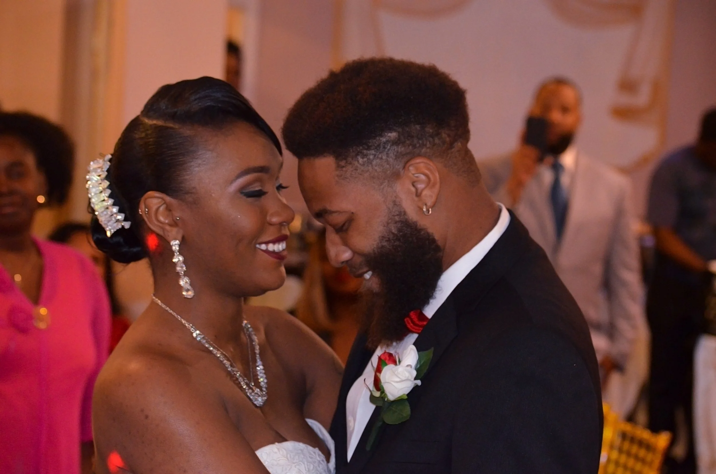 A newly married couple shares their first dance together, holding each other closely as they celebrate their wedding reception.