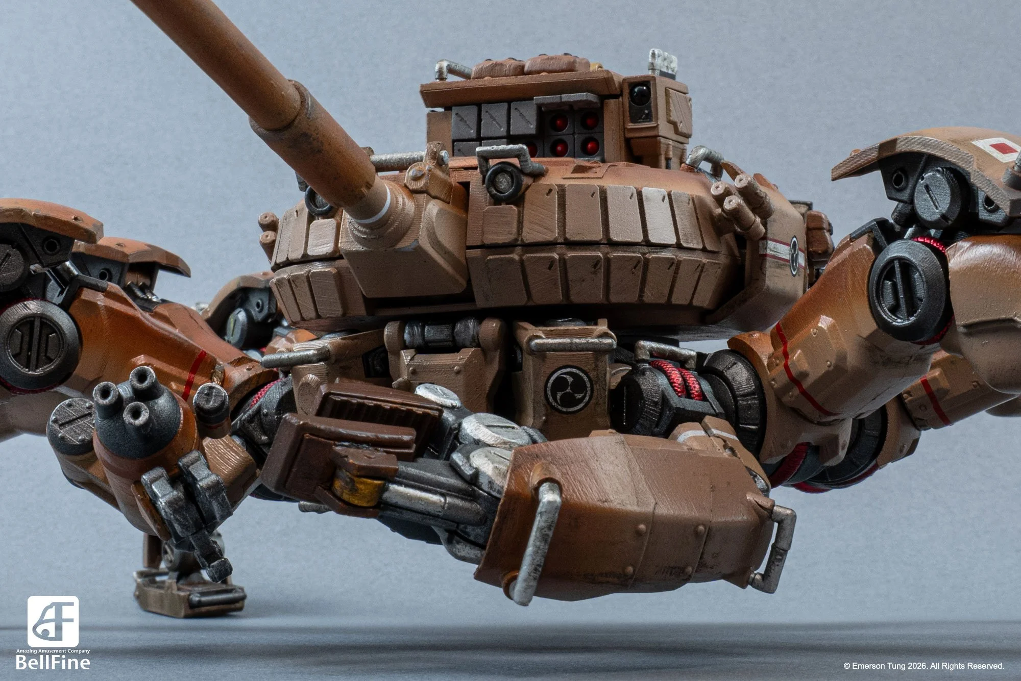 Close up of a detailed plastic model of the Type 33 Heikegani crab tankhead, from Emerson Tung's TANKHEAD IP. It's a tan-colored, robotic crab with multiple legs and mechanical components, on a gray surface.