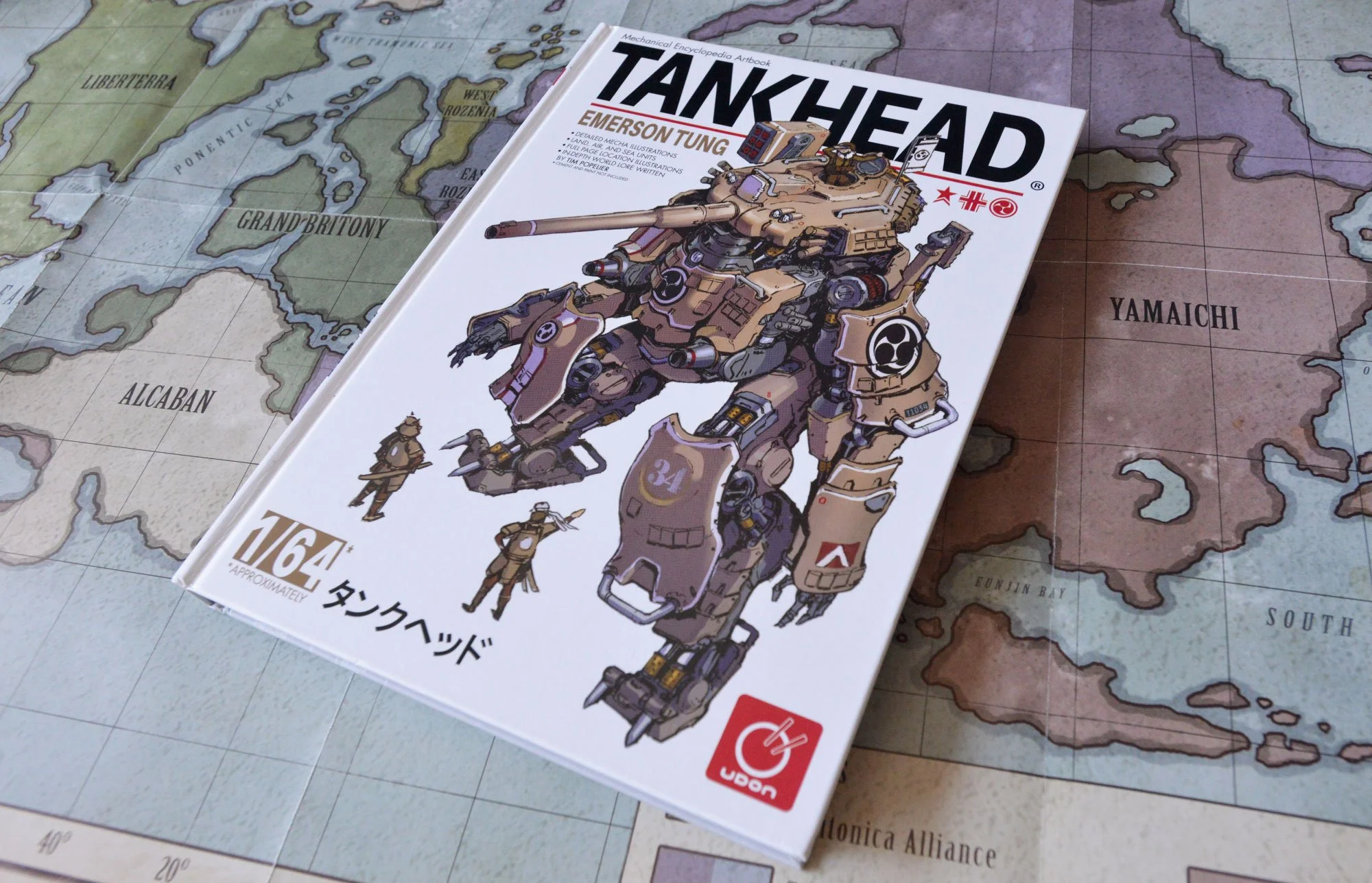 An illustrated hardcover book titled "Tankhead" by Emerson Tung resting on a fictional map of Earde.  The book features a detailed illustration of a large tank robot on the cover.