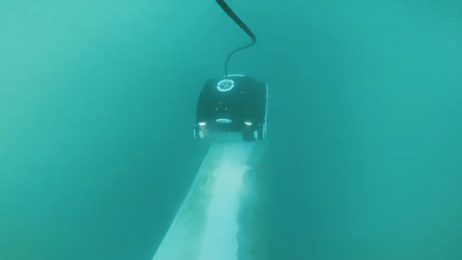 A remotely operated underwater robot descending into the ocean cleaning a keel in Auckland.