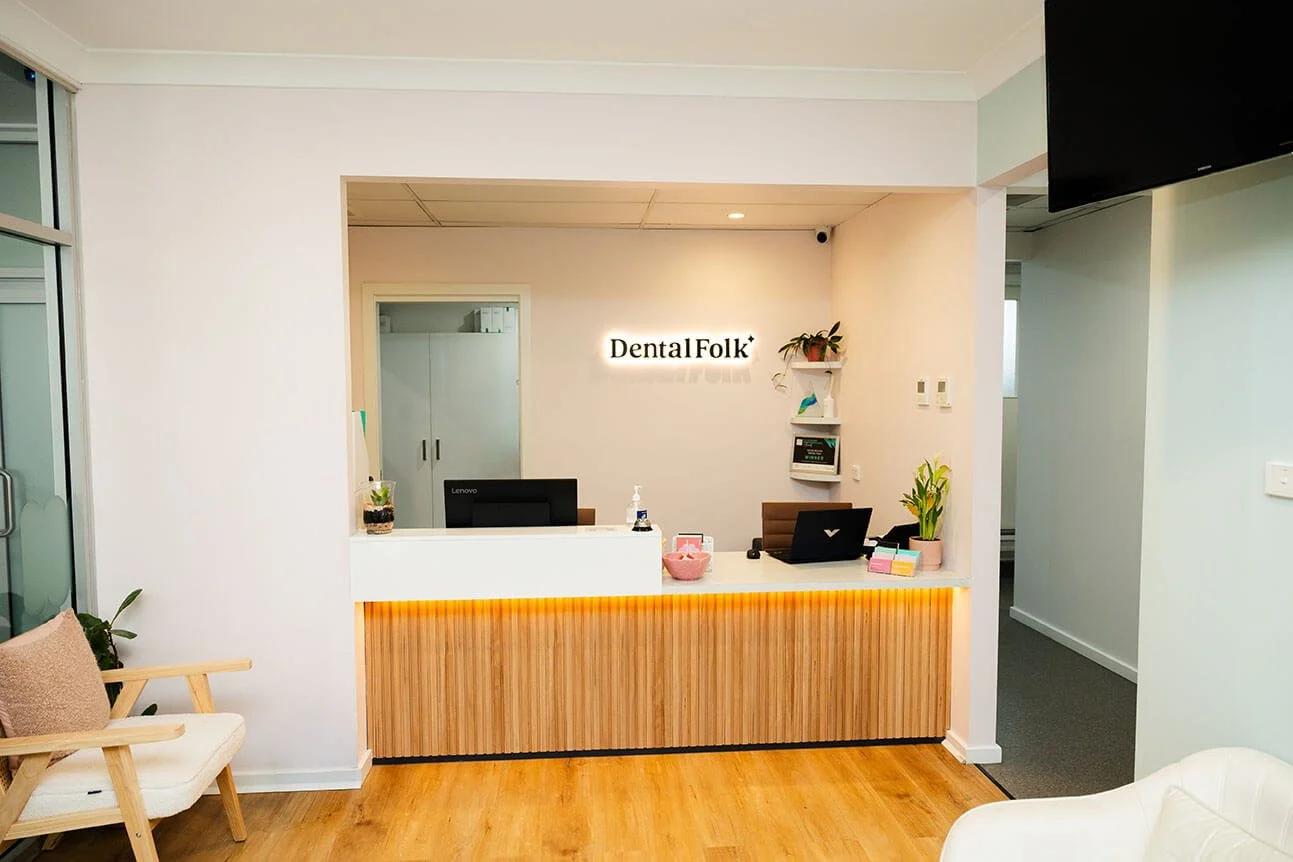 A front desk with the Dental Folk logo above it.