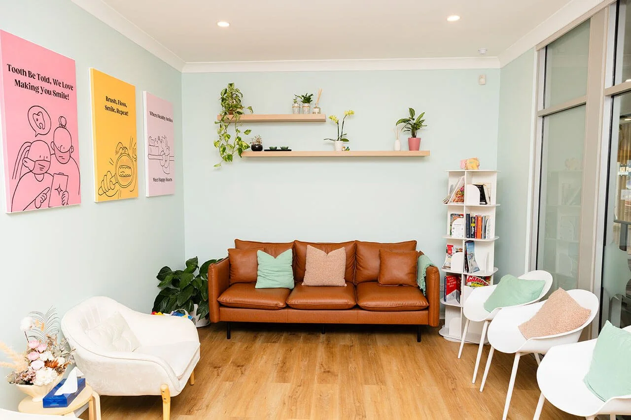 A waiting room with light teal walls and chairs.