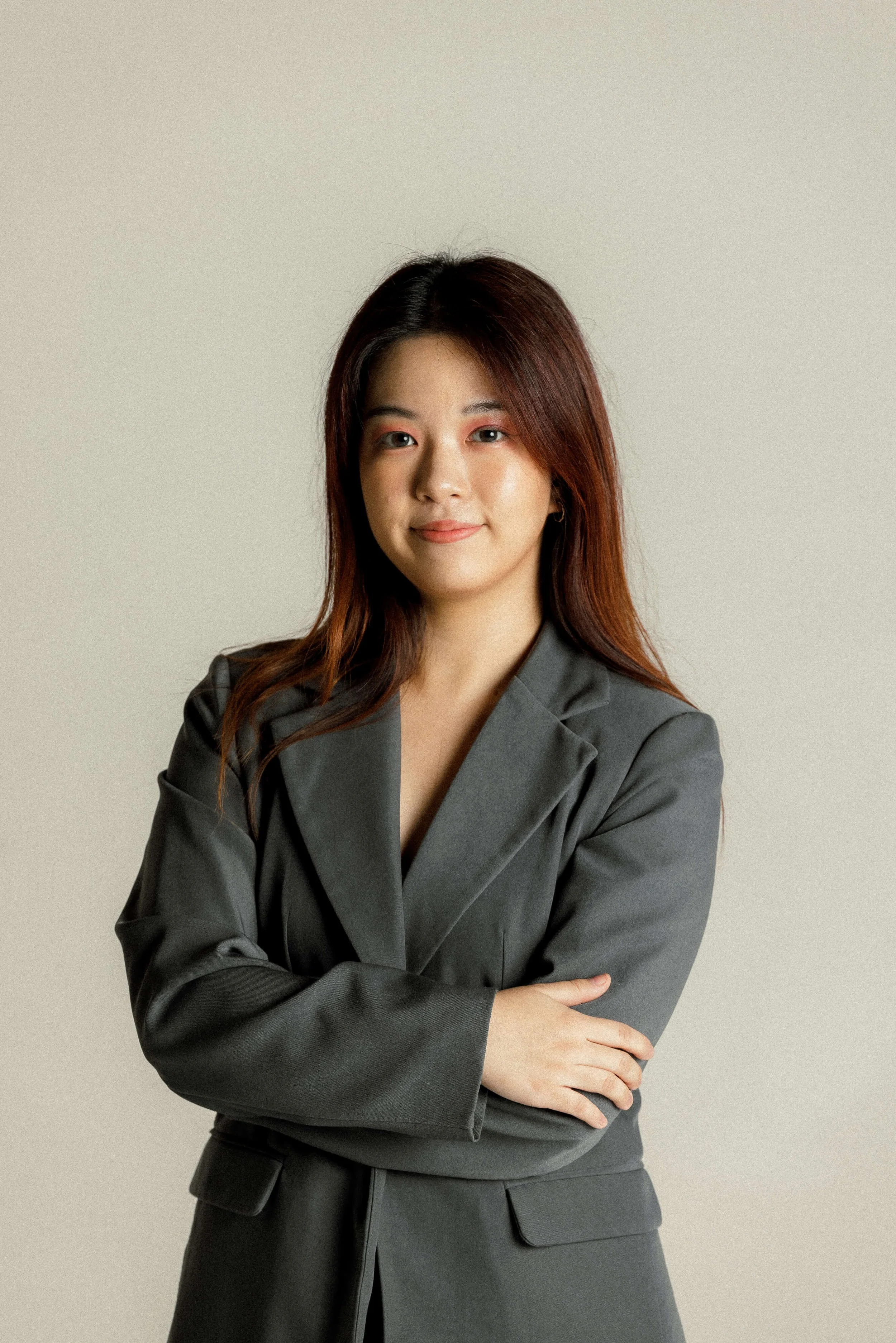 Ying standing smiling with her arms crossed.