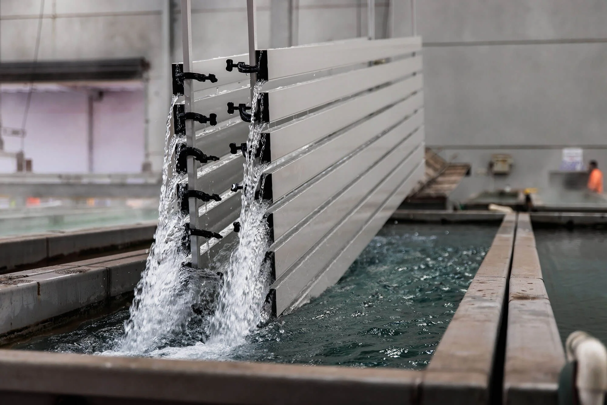 An aluminium structure being lifted out of a pool of water.
