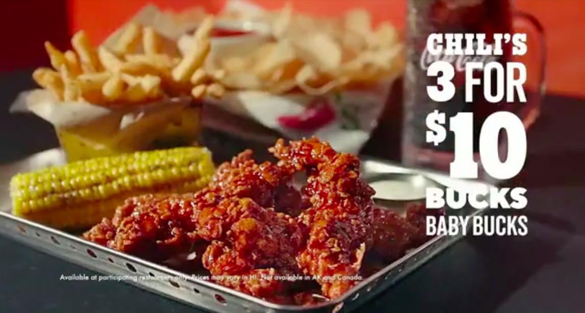 Fried chicken wings, corn on the cob, French fries, and a drink on a metal tray with a promotional text offering three chili's Baby Bucks for ten dollars.