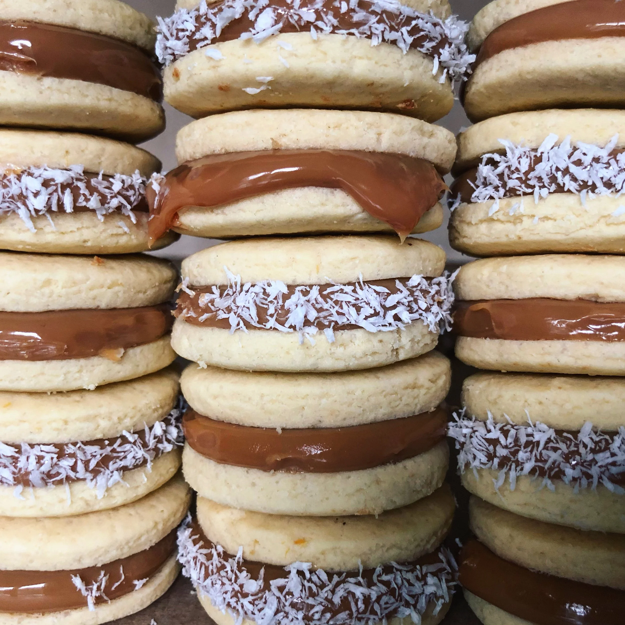 Stacked sandwich cookies with chocolate filling, shredded coconut, and vanilla cookies.