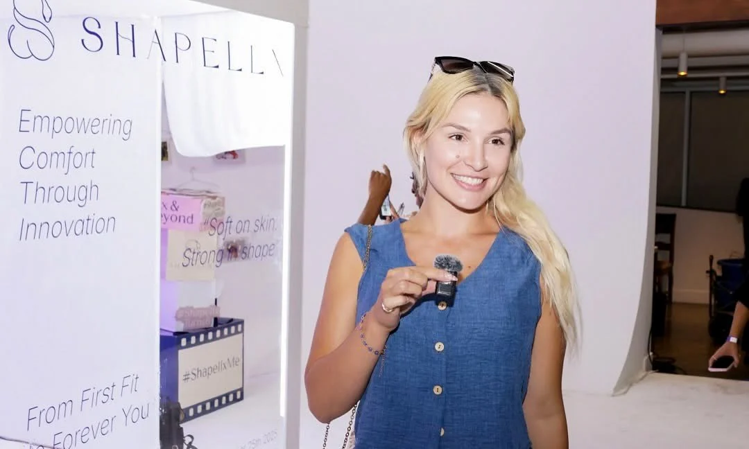 A content creator reporting in the cyc wall area at Shapellx's 6th anniversary activation in Los Angeles.