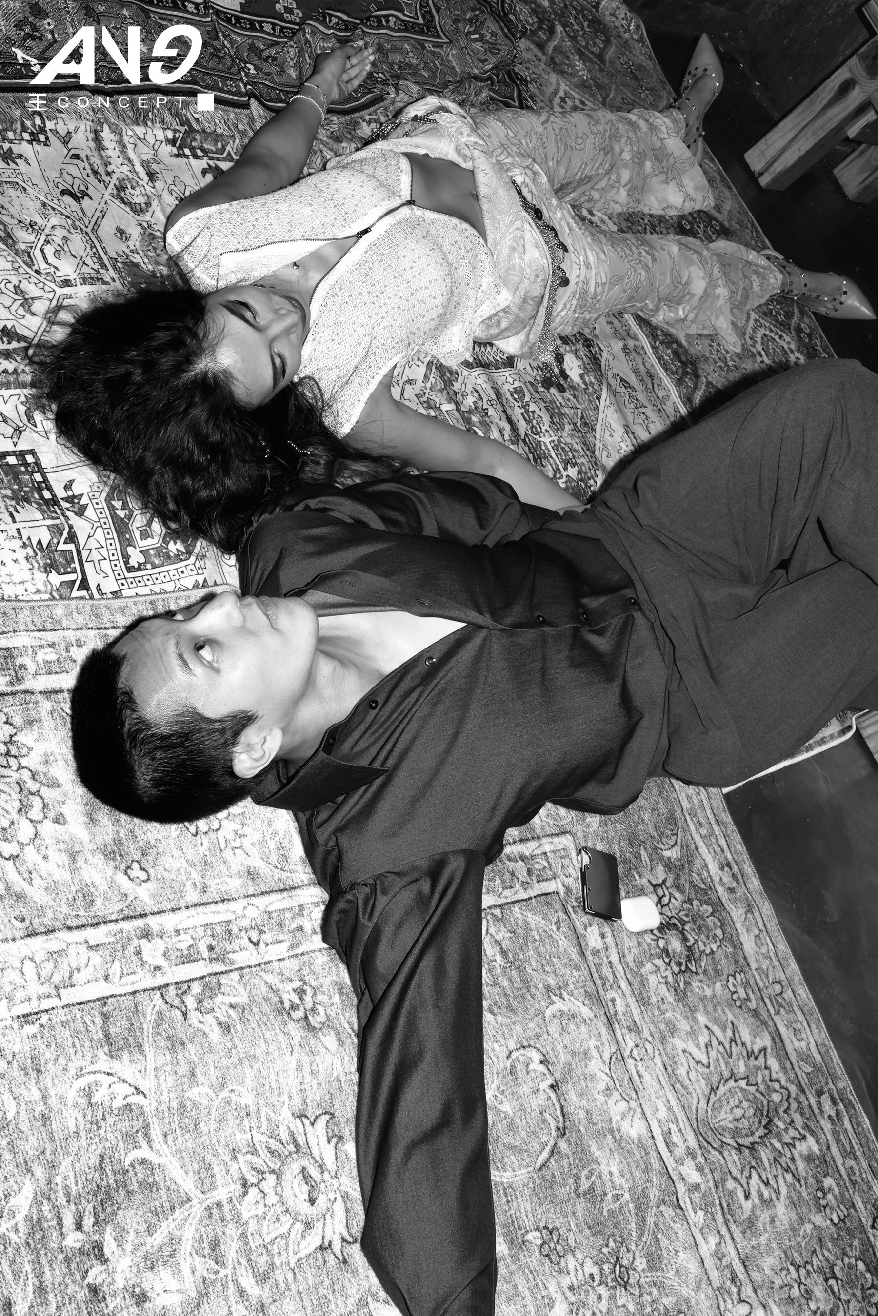 Two people lying on a patterned rug in a relaxed pose at the Lay Party by New York-based event production agency ANG Concept.