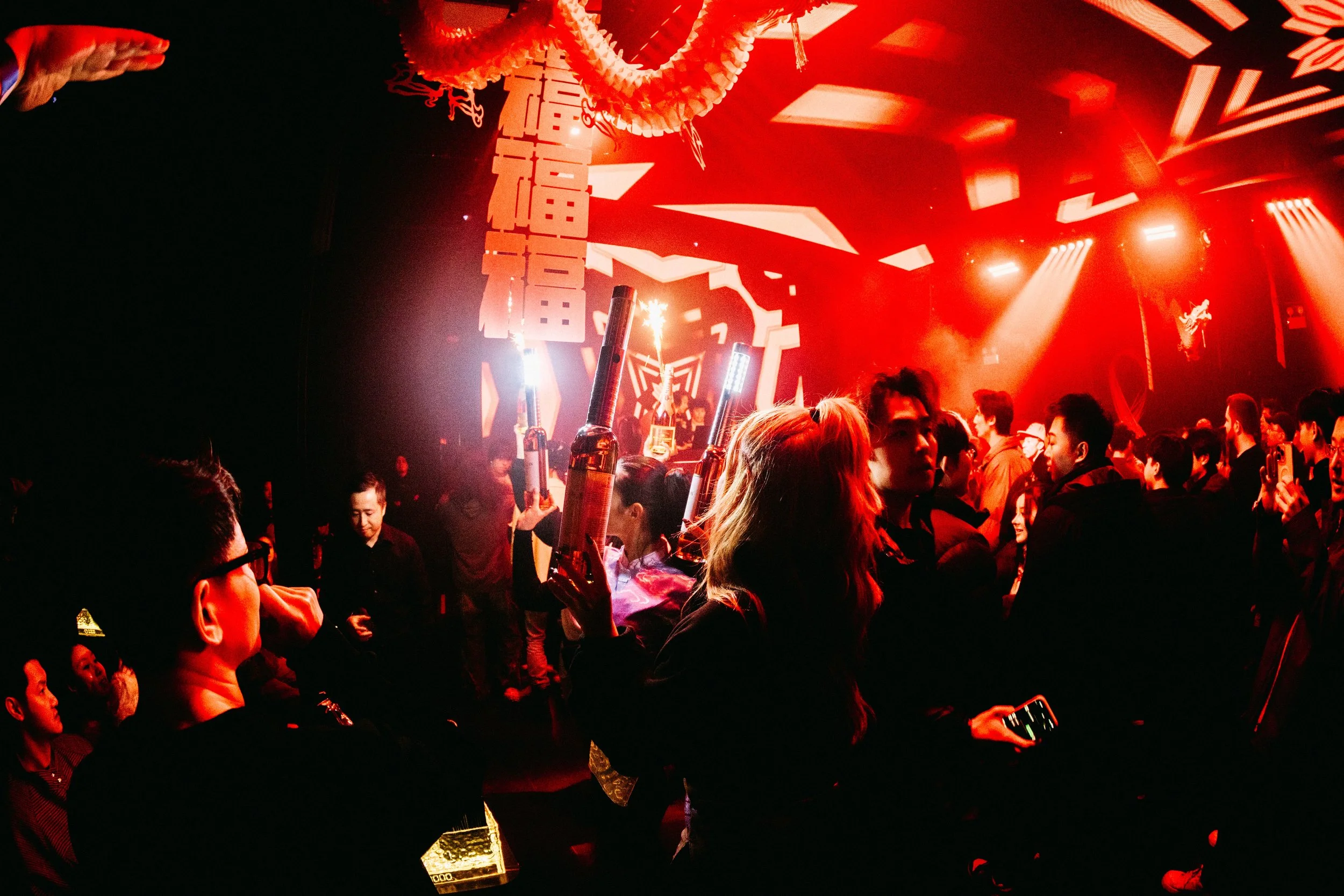 Crowd dancing under the spring festival-themed visuals and decorations at experiential production agency ANG Concept's Lunar New Year Party.