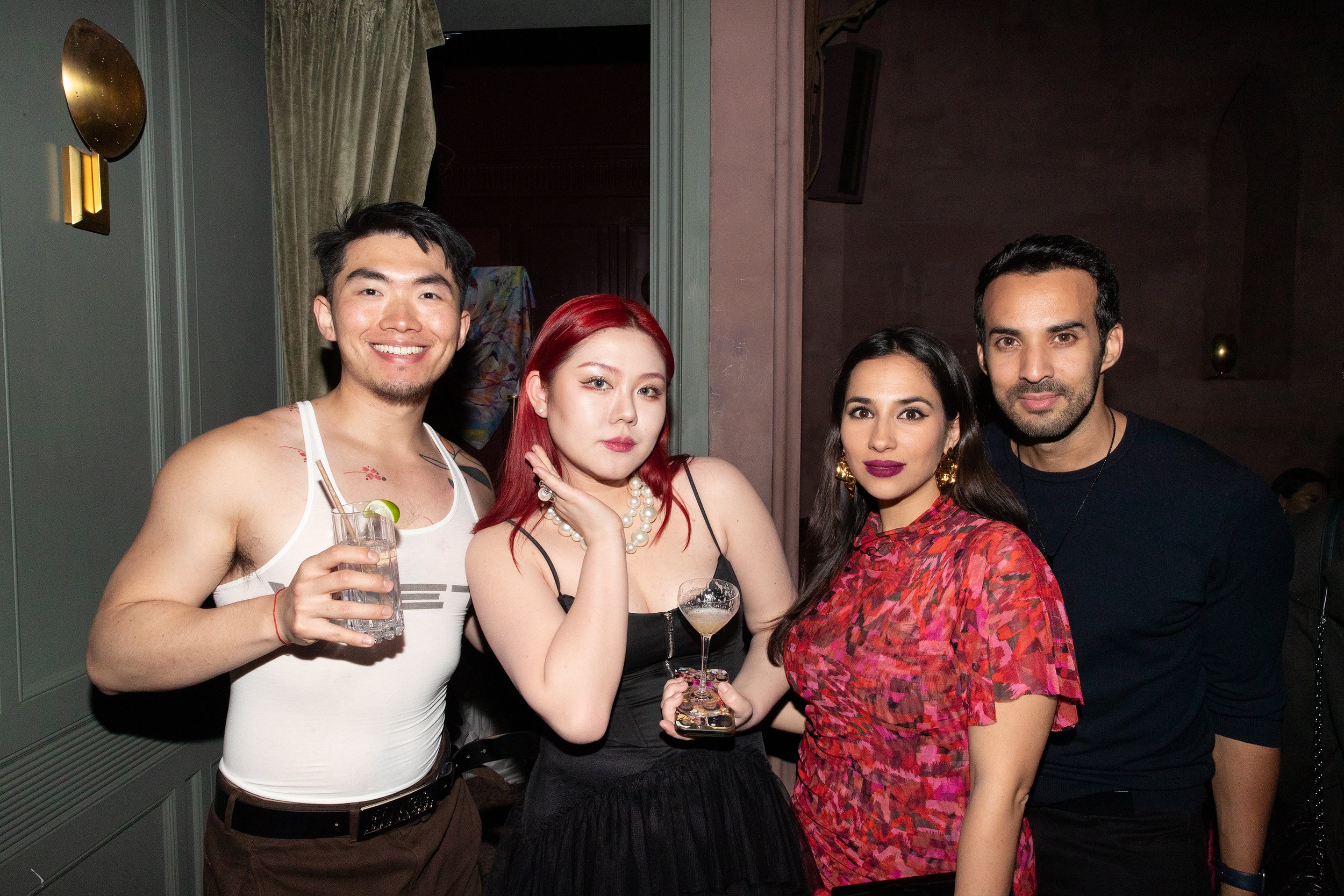 Four VIP guests posing for a photo at the secret launching party "La Genèse" of ANG Concept at Chapel Bar in Fotografiska New York at the time.