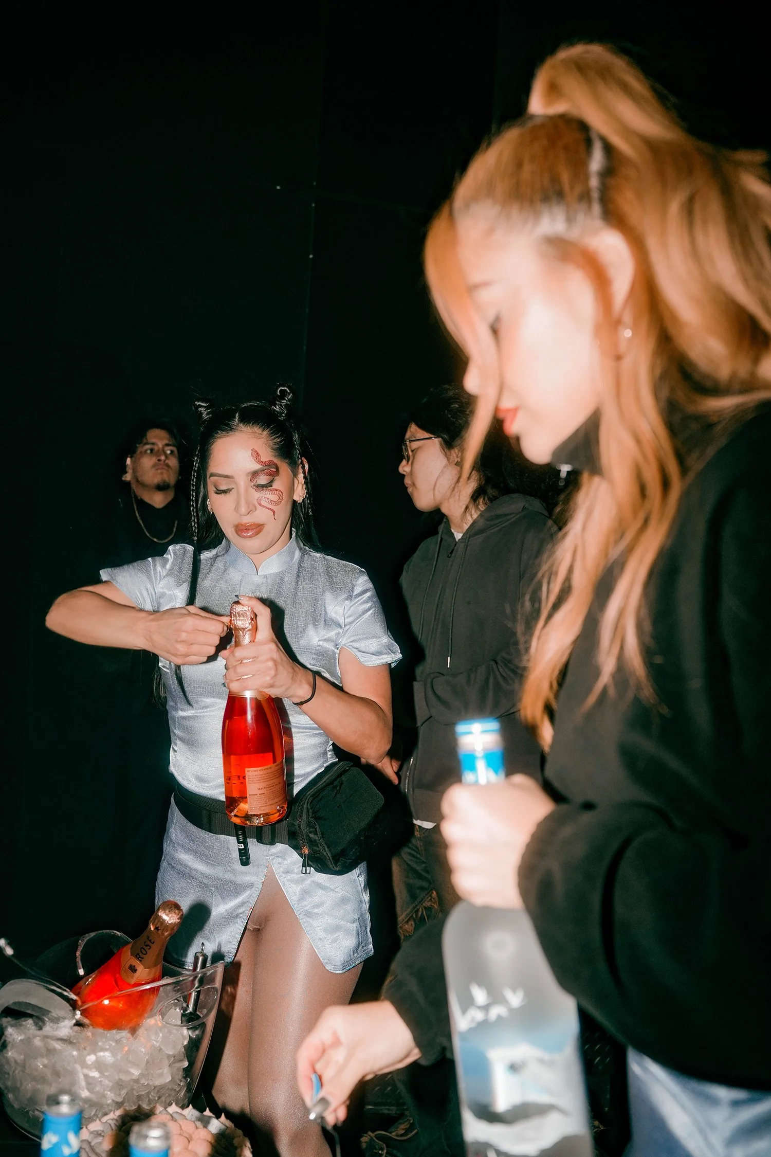 Bottles are being served to the table guests of 00:00 Midnight Club at experiential production agency ANG Concept's Lunar New Year Party.