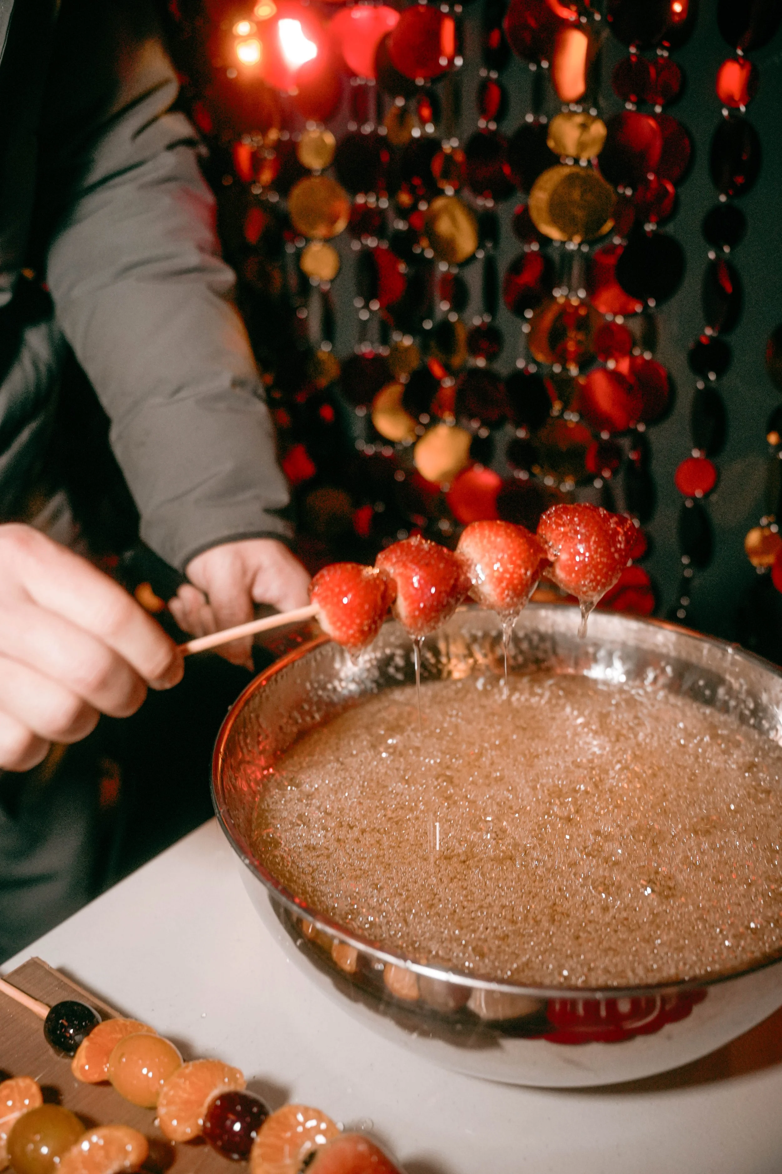 The vendor making Chinese candied fruit with fresh strawberries at the event production agency ANG Concept's Lunar New Year Party.