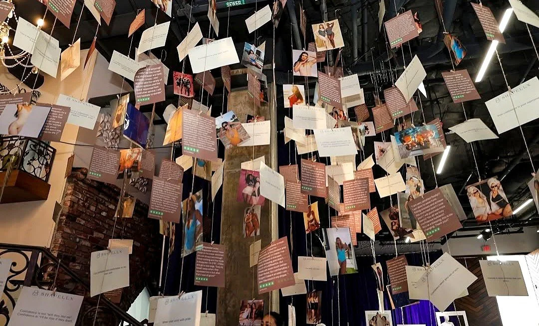 An art installation with numerous campaign pages hanging from the ceiling at Shapellx's 6th anniversary activation in Los Angeles.