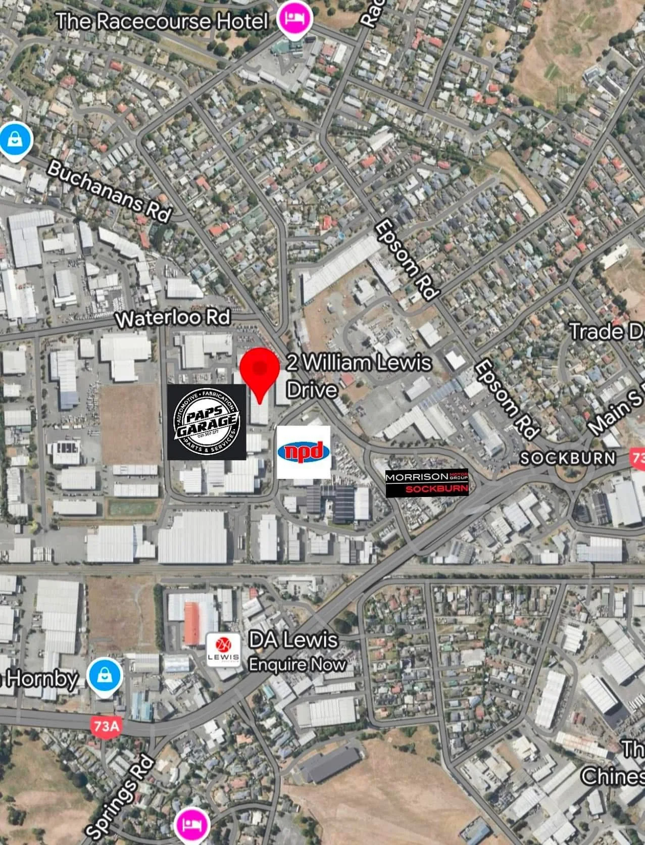 An aerial map showing the location of 2 William Lewis Drive, with nearby roads such as Epsom Road, Waterloo Road, Buchanans Road, and Springs Road. Landmarks include The Racecourse Hotel, an NPD service station, a Morrison group building, and a DA Lewis store, among other businesses and residential areas.