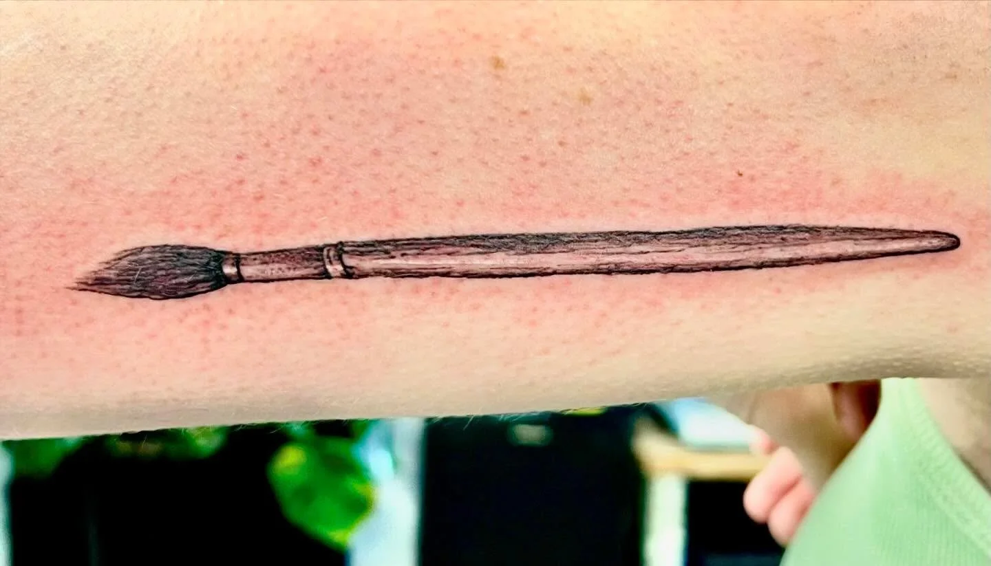 Temporary tattoo of a paintbrush on a person's arm.