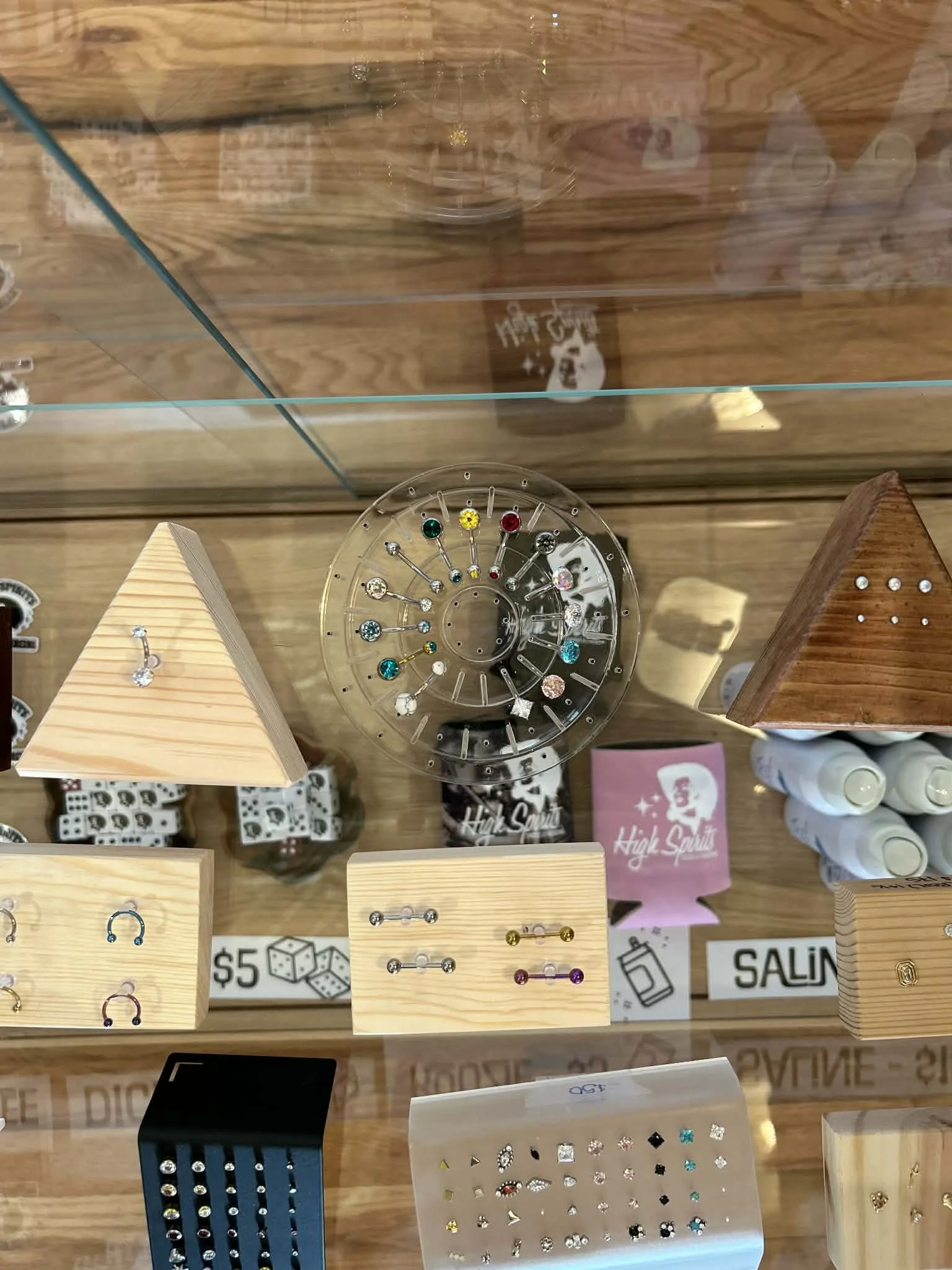 Display case with various earrings, jewelry, and decorative items including colorful gemstones and small accessories.
