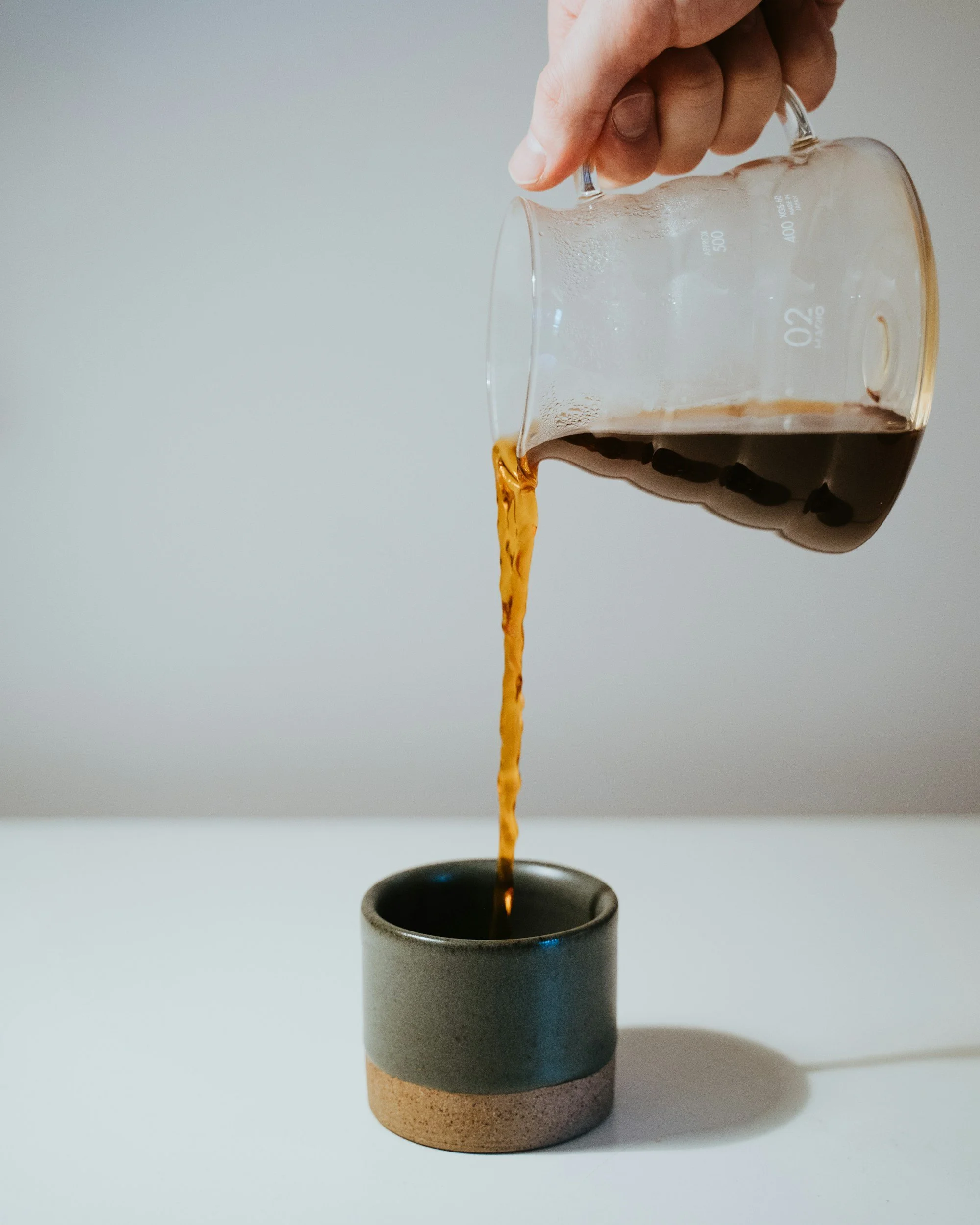 person is pouring a freshly brewed coffee pour over