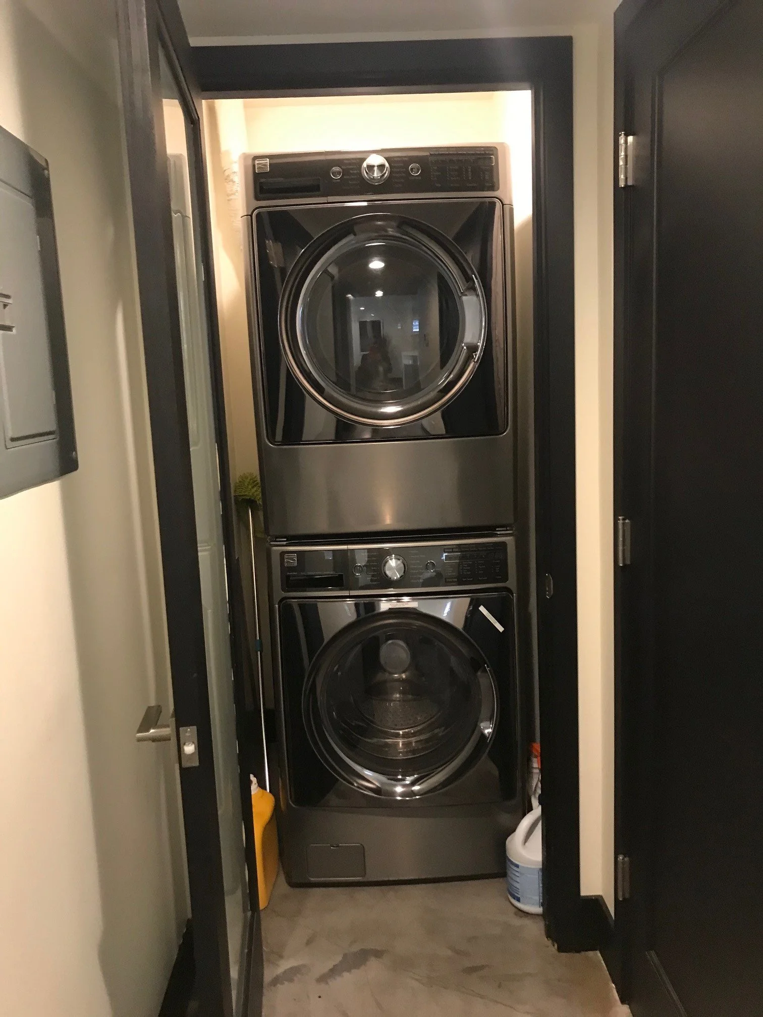 Stacked front-loading washer and dryer in a laundry closet.
