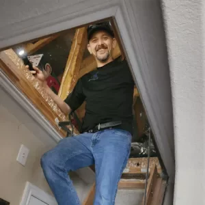 Home inspector Daniel climbing down from an attic with a flashlight during a home inspection in Spring, Texas.