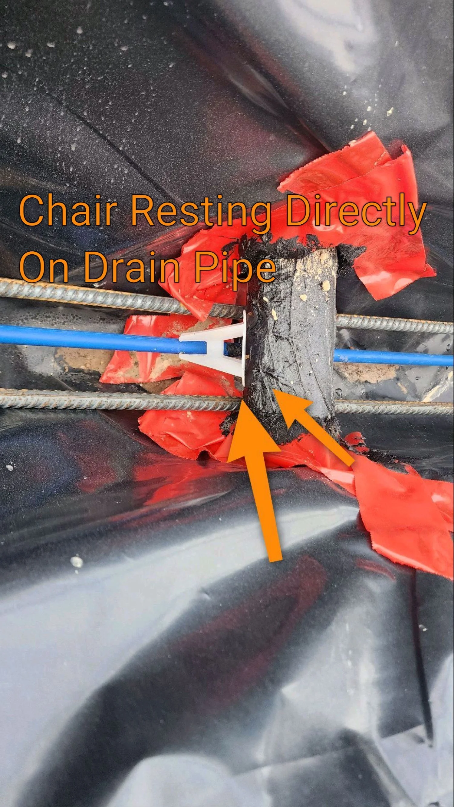 Phase 1 pre-pour foundation inspection photo showing a rebar chair improperly resting on a PVC plumbing vent pipe, which can stress and damage the pipe when the slab is tensioned.