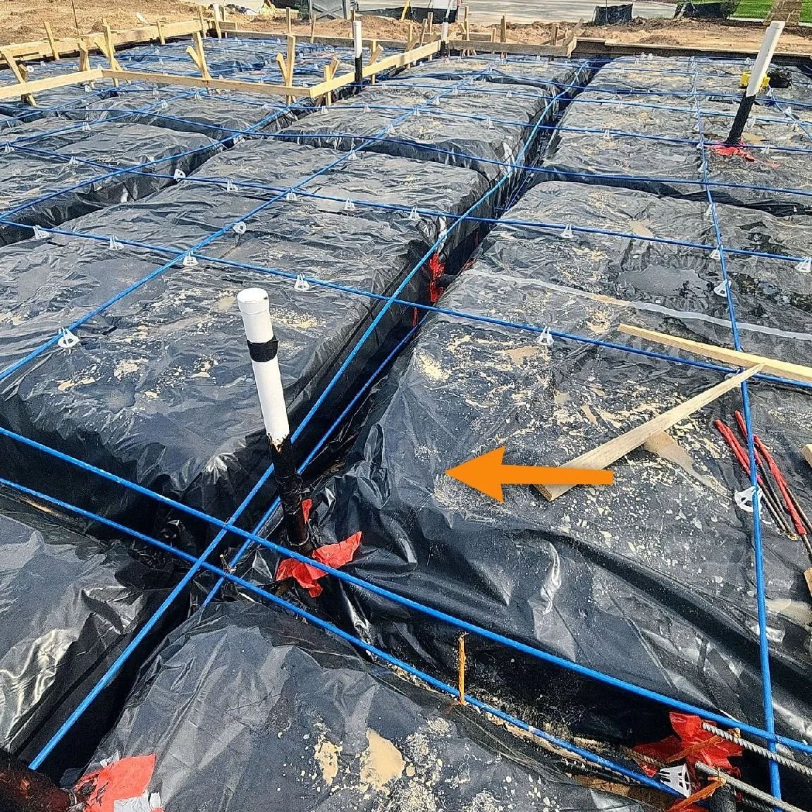 Close-up of a post-tension concrete foundation showing a visible deficiency documented during a phase inspection before the slab is poured.