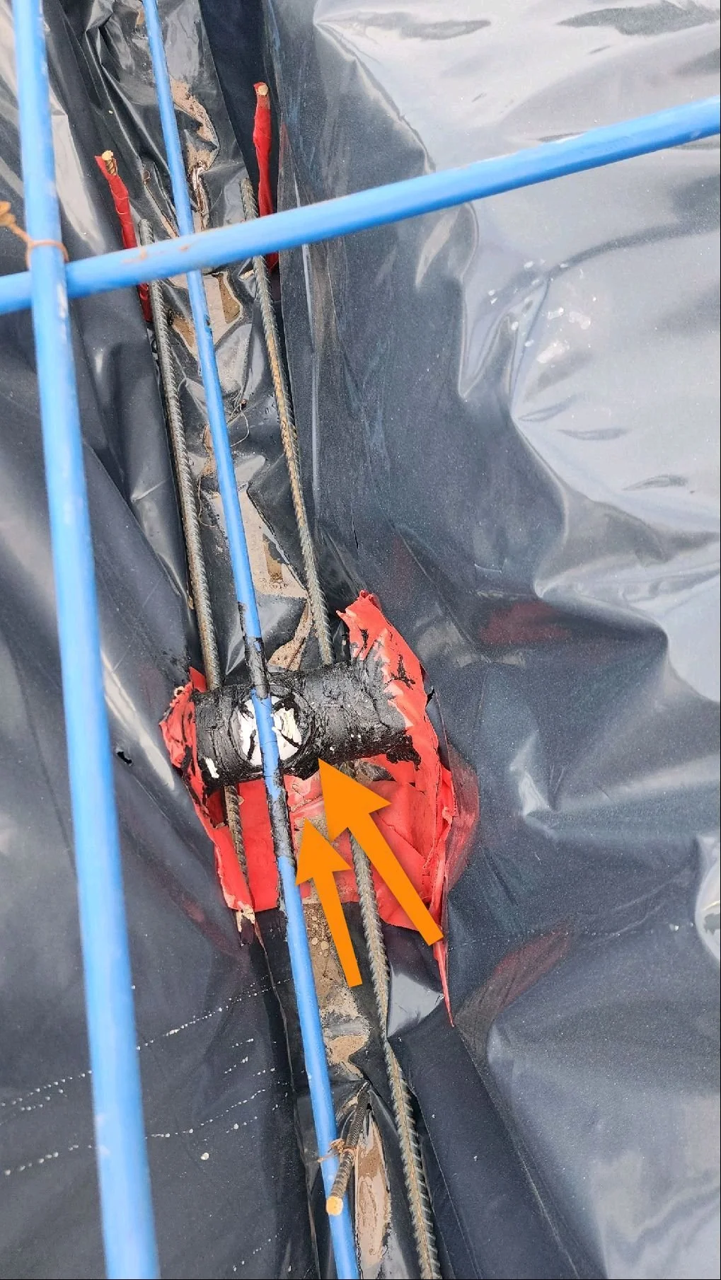 Phase 1 pre-pour foundation inspection photo showing a rebar chair improperly resting on a PVC plumbing vent pipe, a defect that can stress and damage the pipe when the slab is poured.