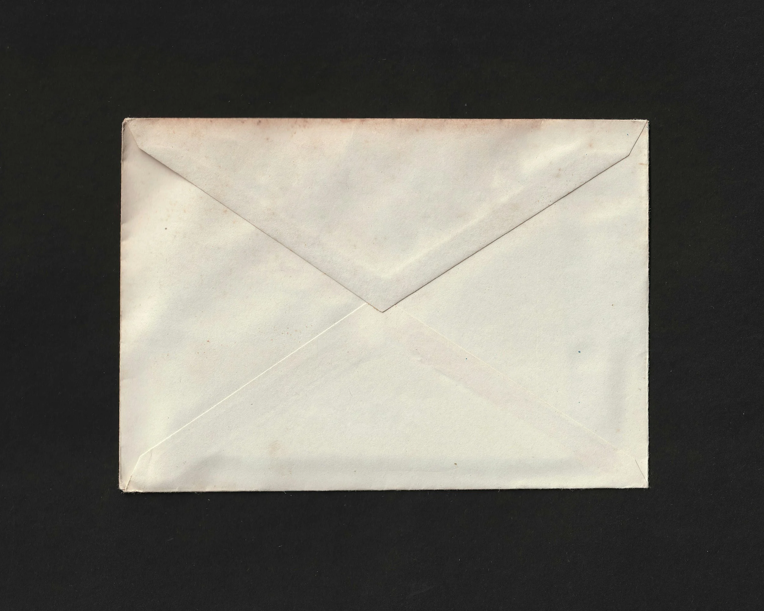 A white envelope lying flat on a black surface.