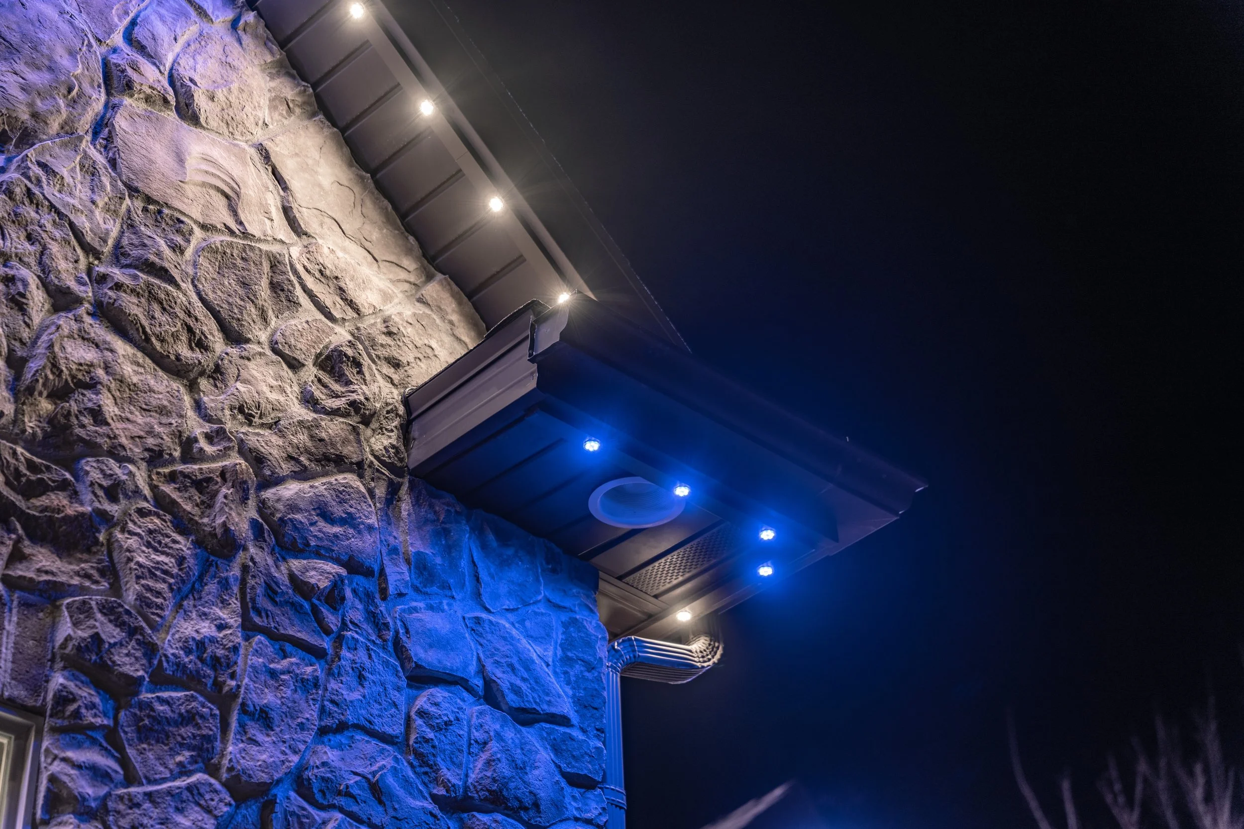 Outdoor LED lighting system installed on a stone exterior wall in Utah with accent lighting effects.