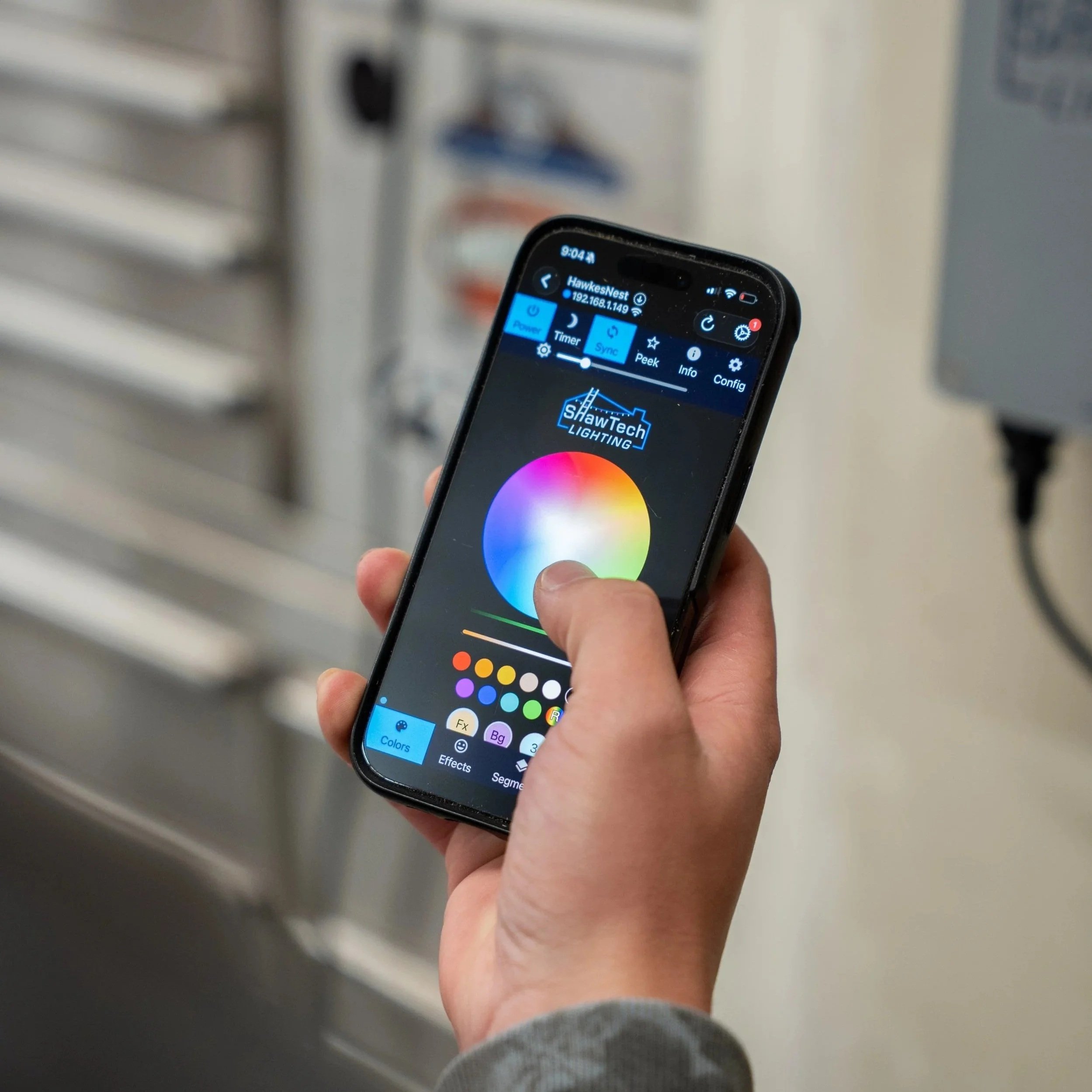 App-controlled outdoor lighting system adjusting colors on a smartphone for permanent LED lighting in Utah.