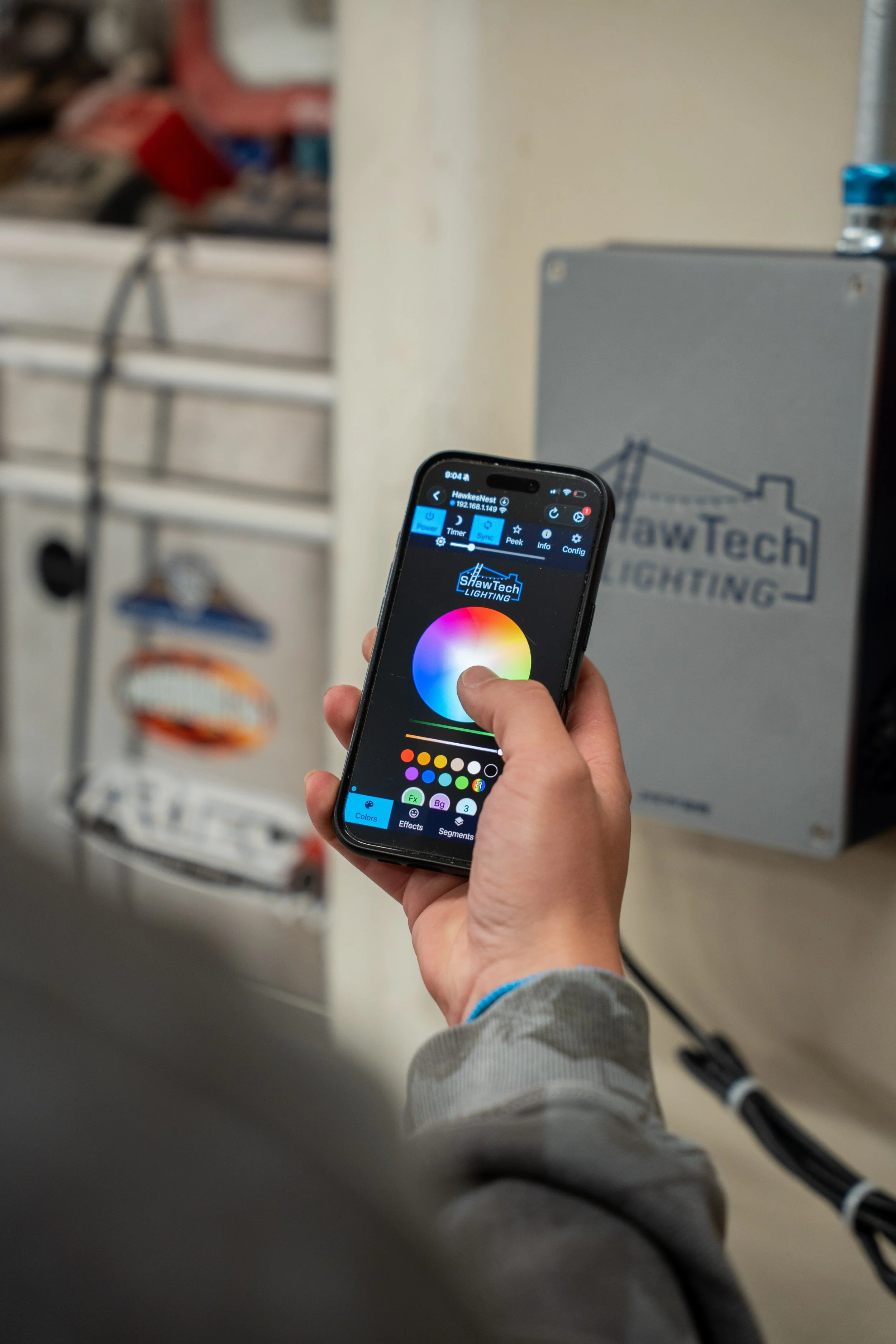 Smartphone controlling permanent outdoor LED lighting colors for a residential roofline lighting system in Northern Utah.