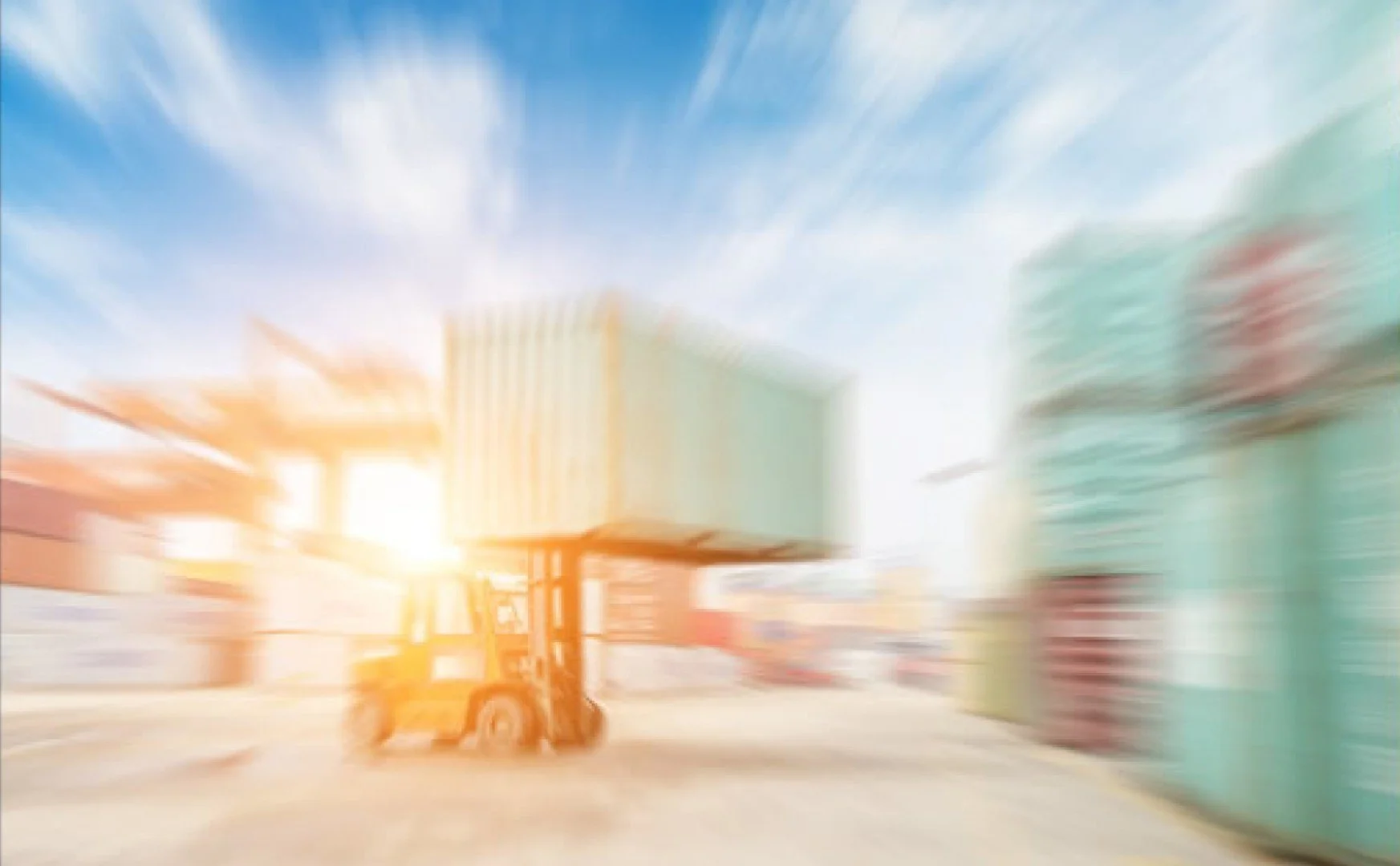 A forklift in a colorful industrial warehouse during sunset with blurred shelves and crates.
