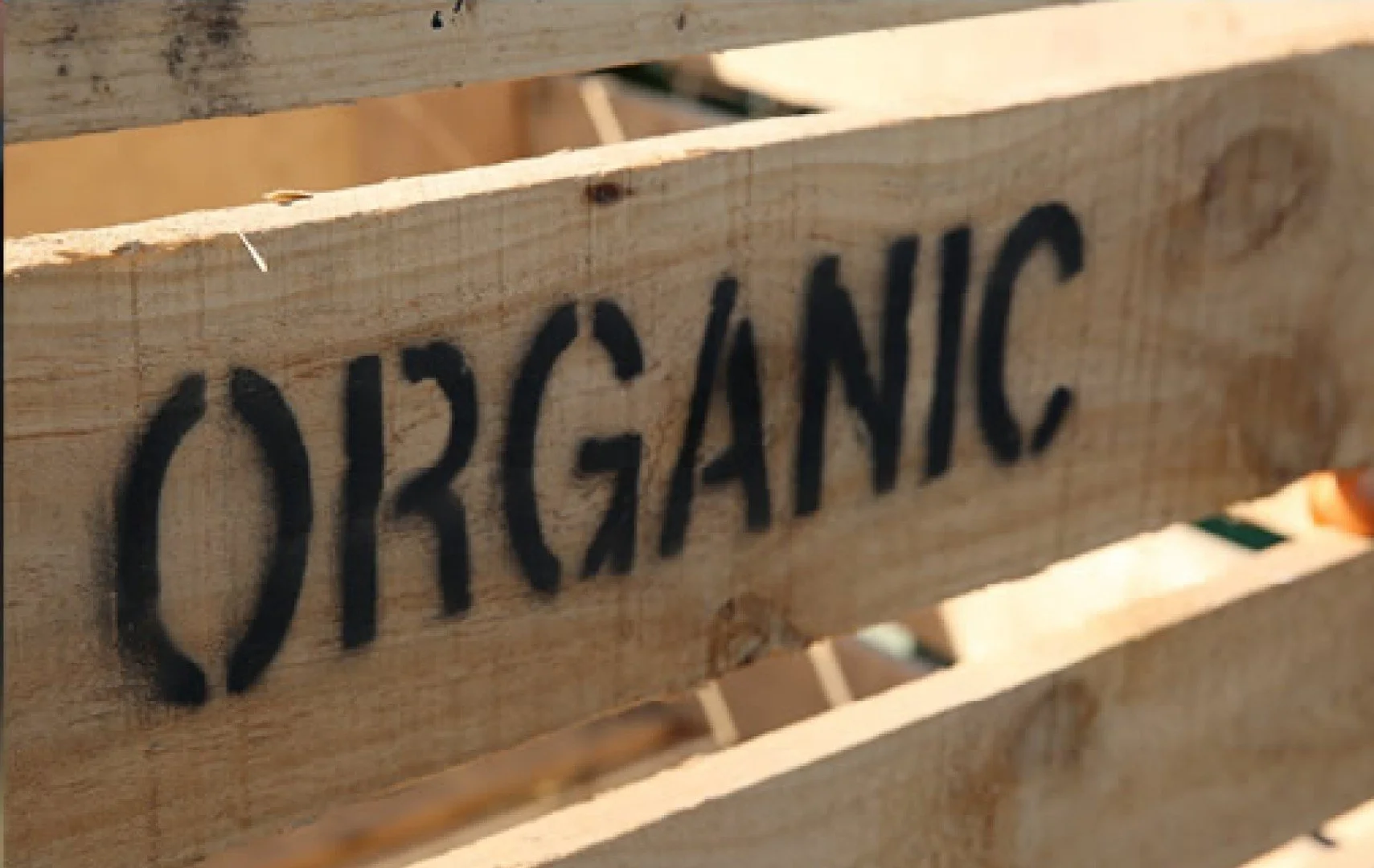 Wooden crate with the handwritten word 'ORGANIC' on it.