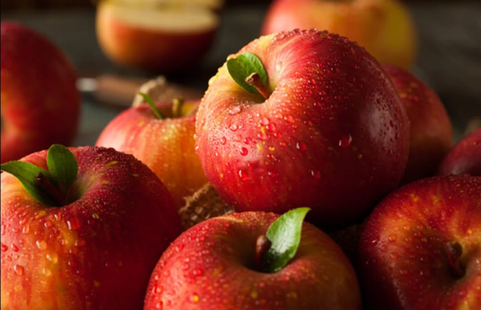 Close-up of fresh red apples with water droplets on their surface.