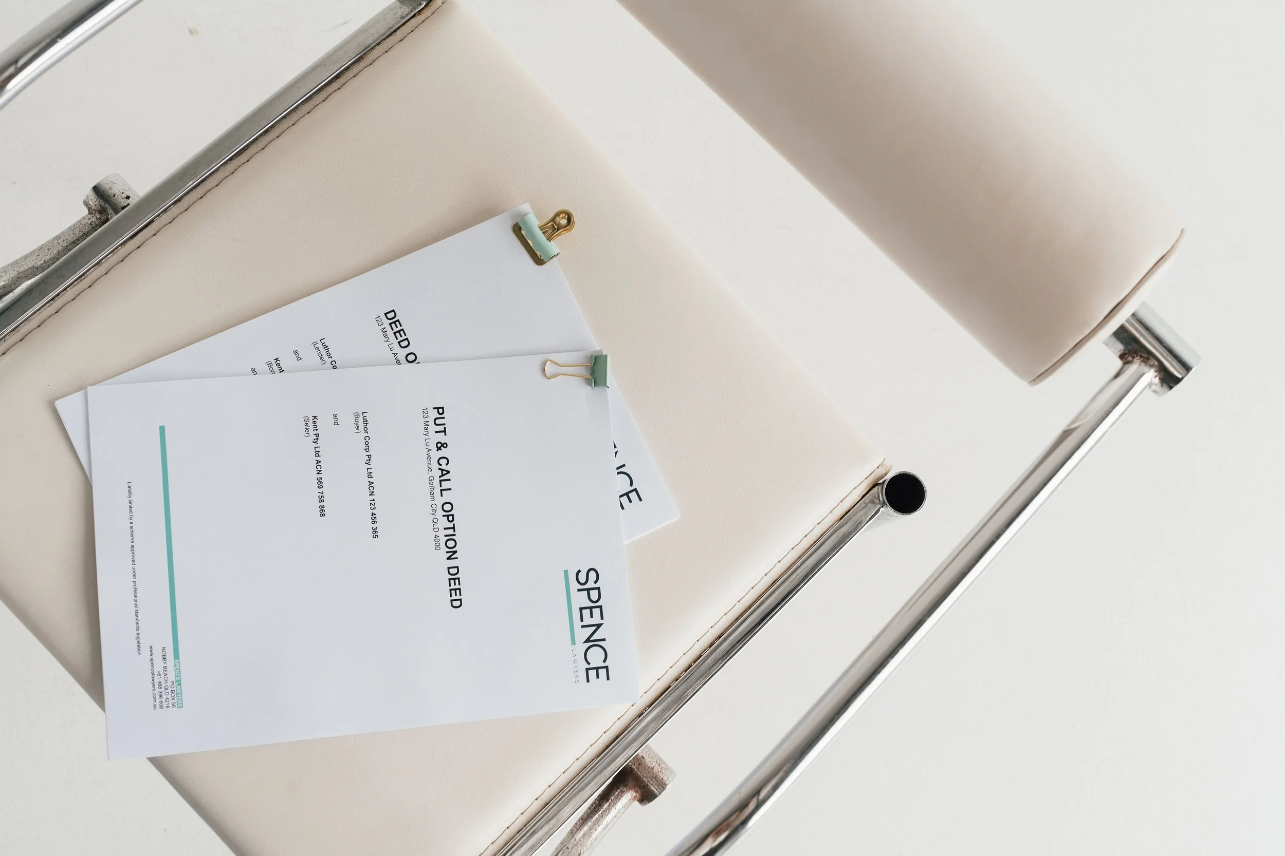 Medical examination room with a beige examination table and two prescription sheets clipped with clothespins.