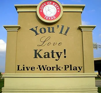 Sign reading 'You’ll Love Katy! Live Work Play' with the City of Katy, Texas logo at the top.