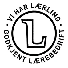Sirkulært logo med stort L i midten, omringet av teksten 'Vi har lærling' øverst og 'Godkjent lærebedrift' nederst.