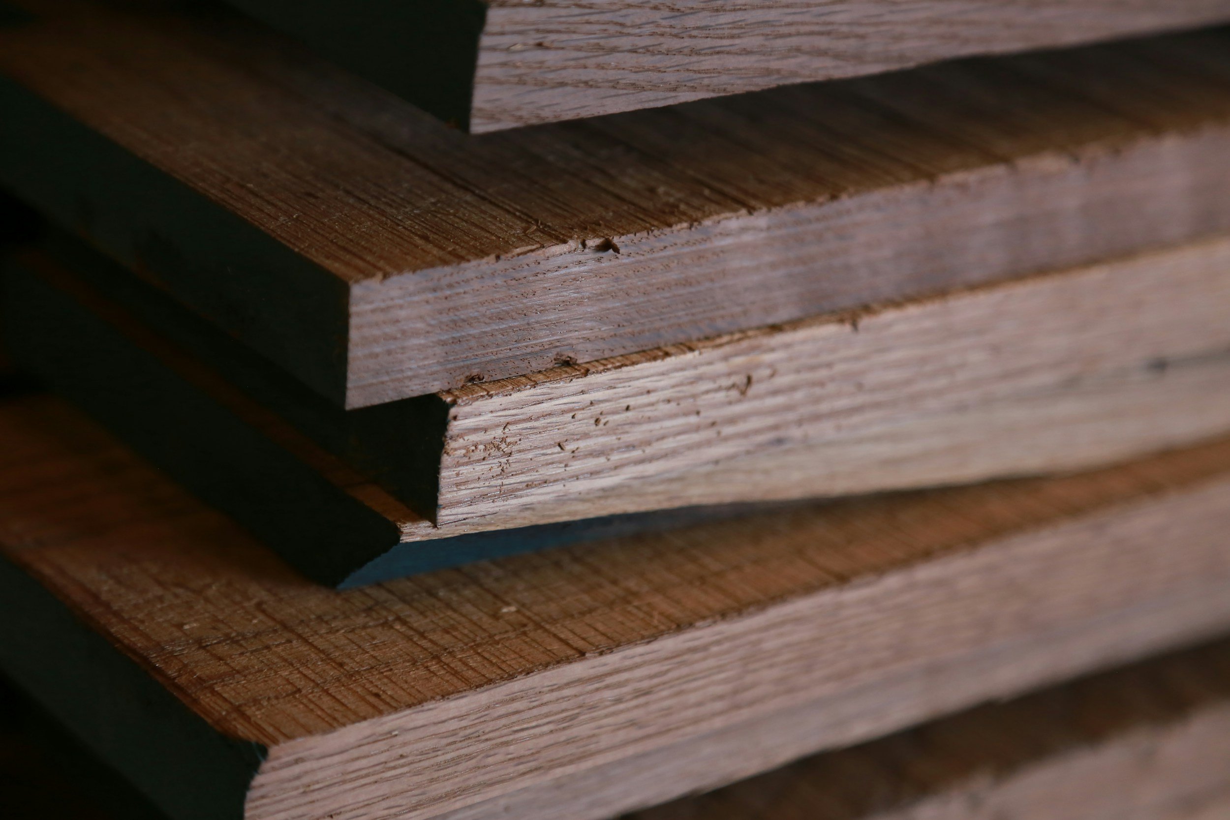 Close-up of stacked wooden planks with varied wood grains and colors.