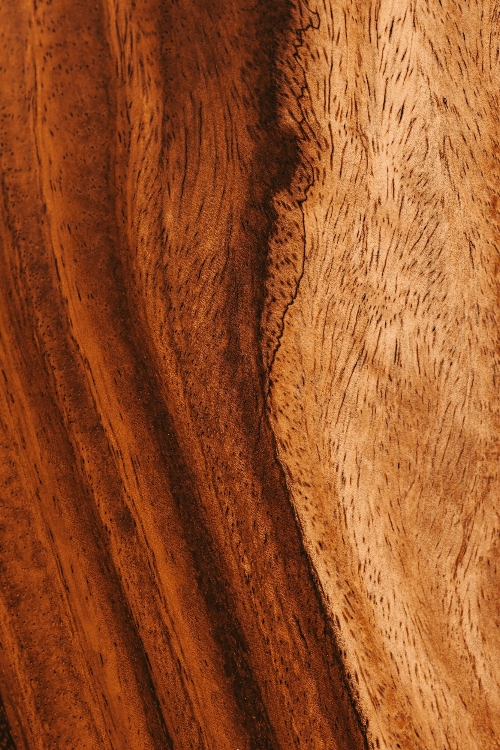 Close-up of a wooden surface showing natural grain patterns and color variations.