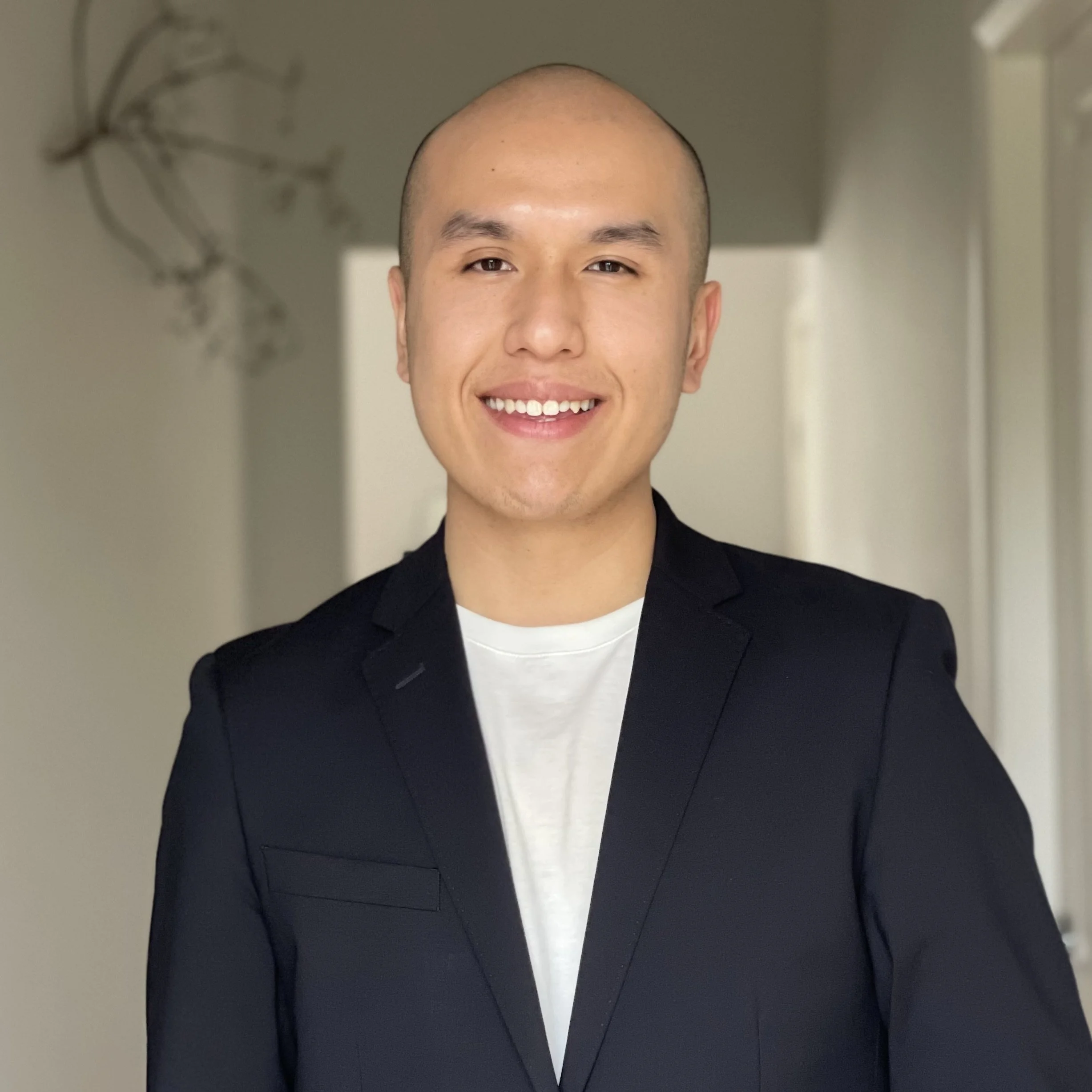 Headshot of smiling male tutor with medium-length black hair wearing a lanyard.
