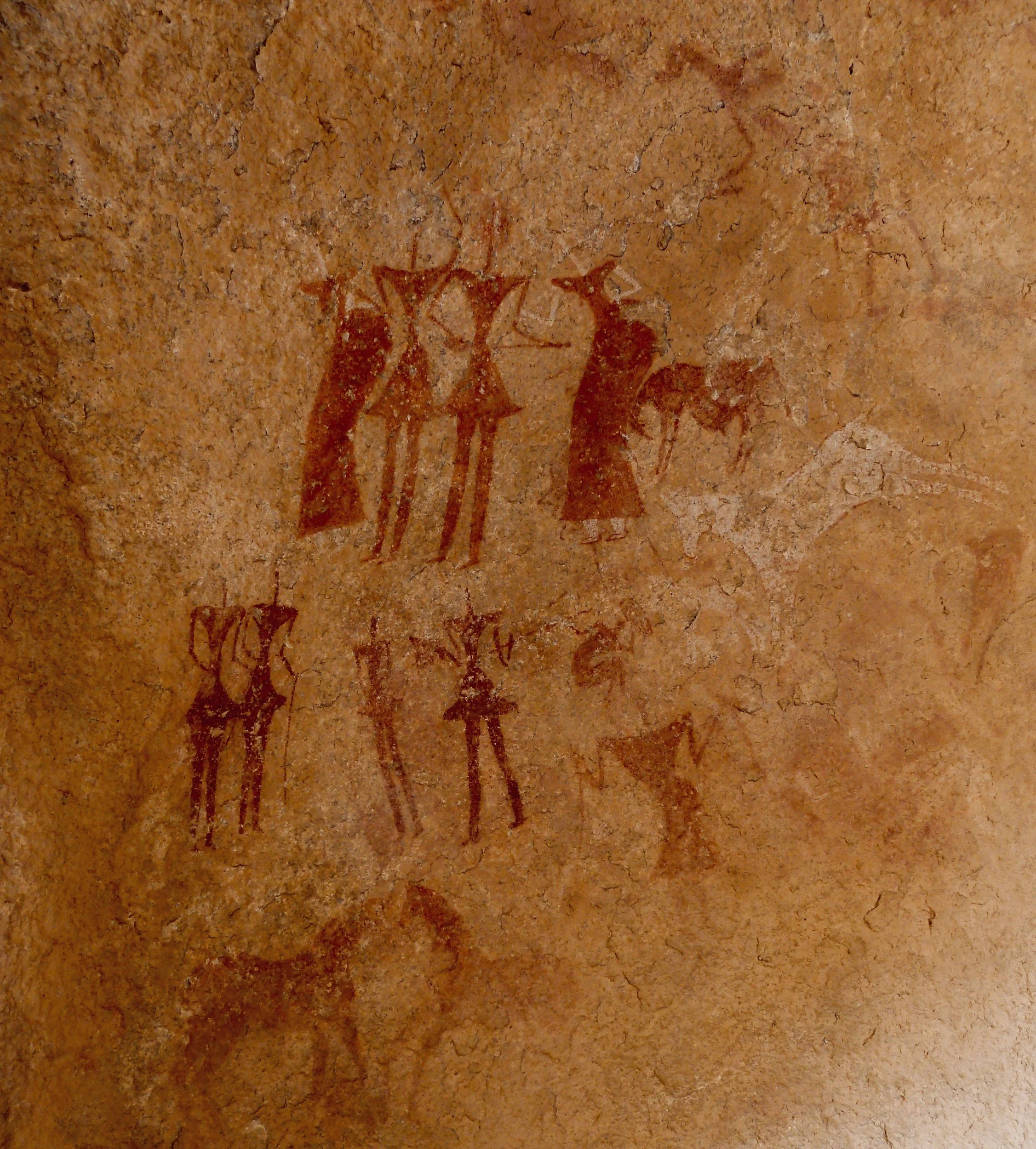Ancient cave painting depicting four human-like figures with elongated limbs and hats, grouped together, with a horse figure to the right.