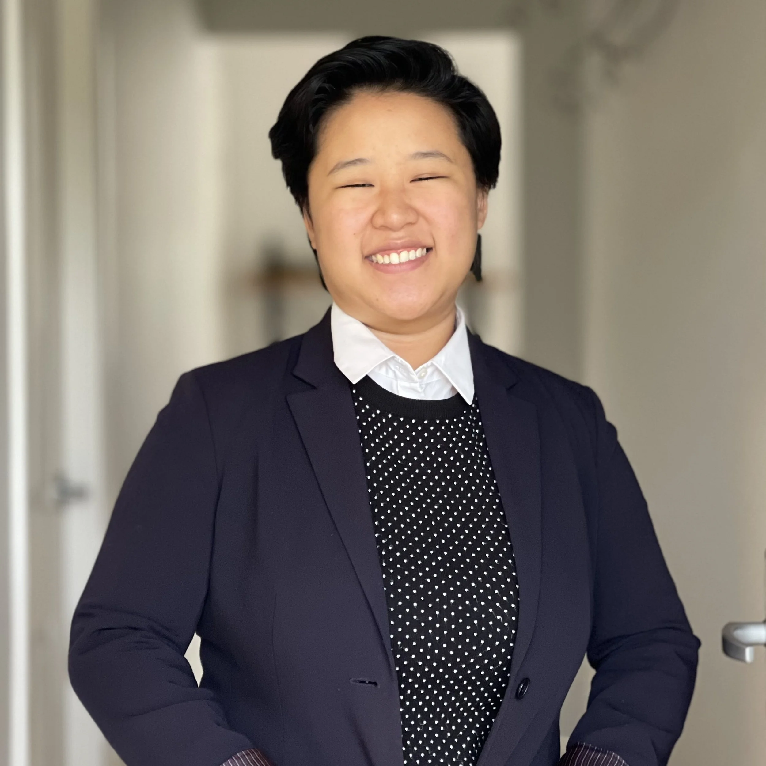 Headshot of smiling female tutor with short blonde hair wearing a lanyard.